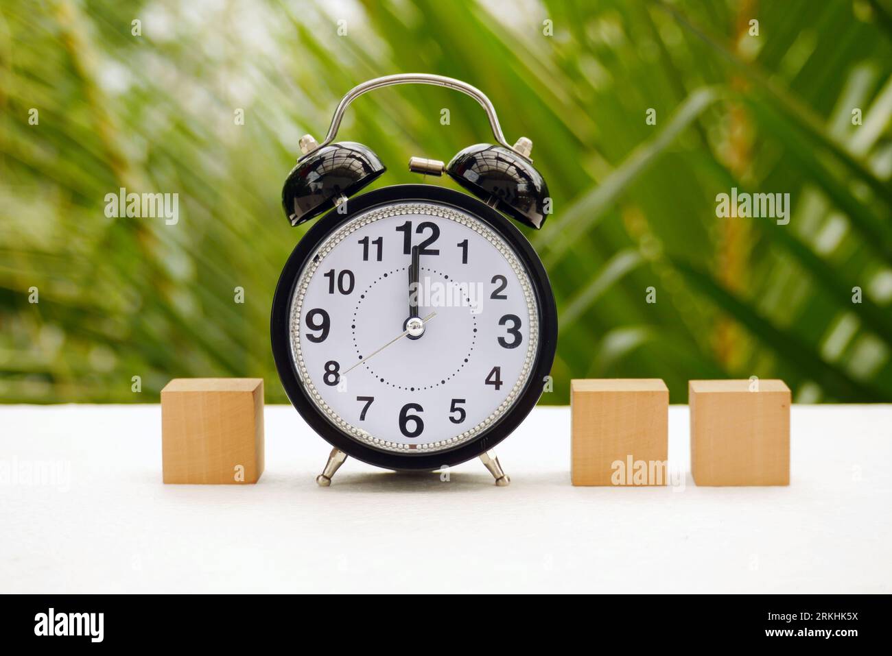 a vintage alarm clock and block with nature background Stock Photo - Alamy