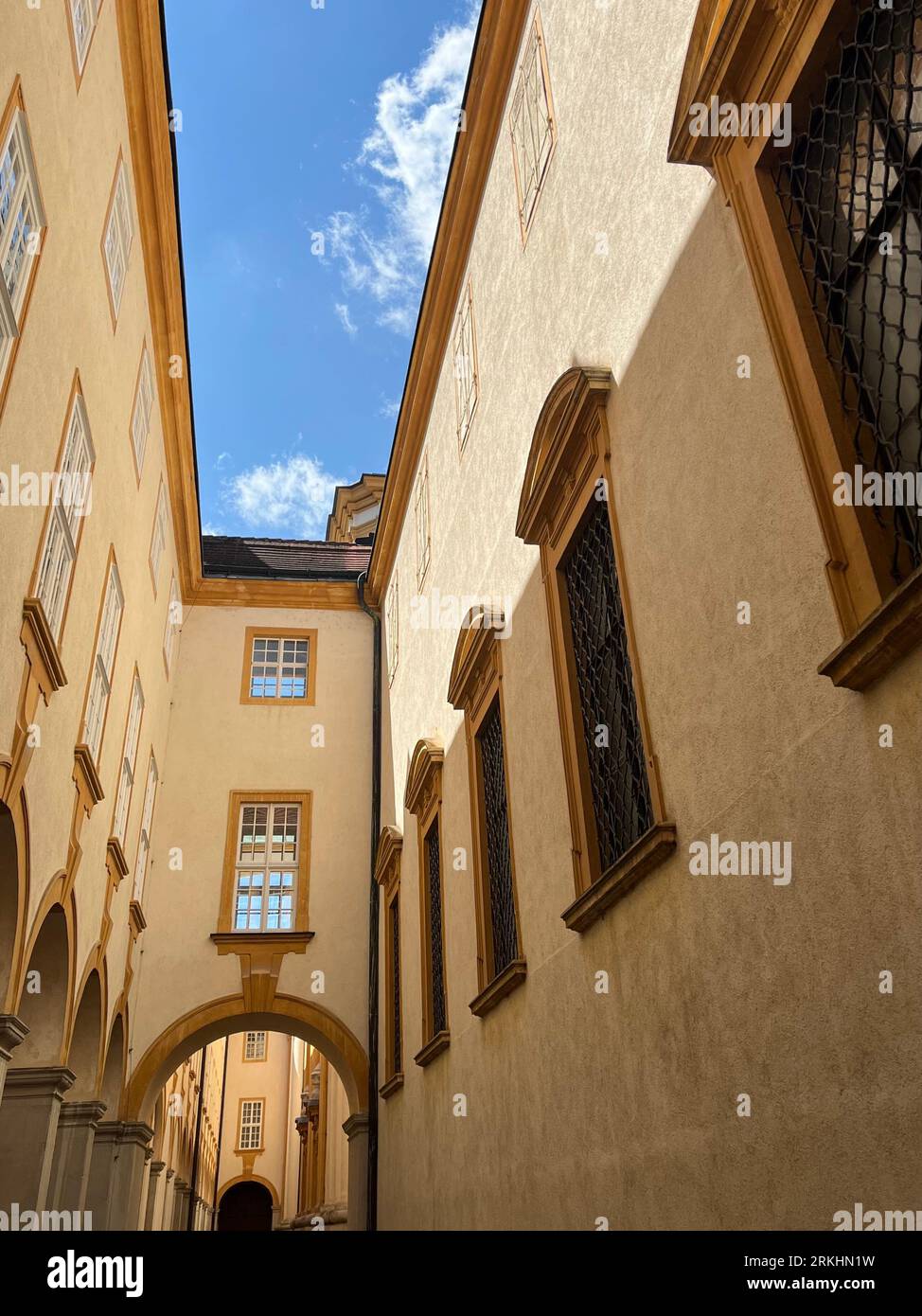 A low angle of a narrow street between old buildings on a sunny day Stock Photo