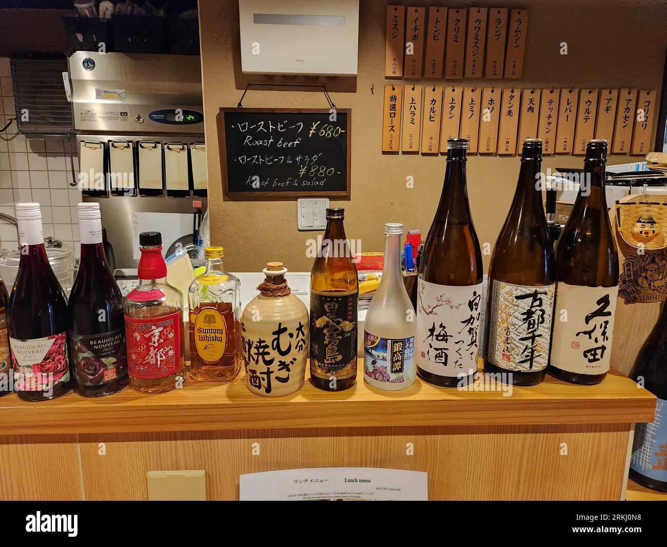A Japanese Sake rice wine and other Japanese labeled bottles in a bar in Kyoto Stock Photo