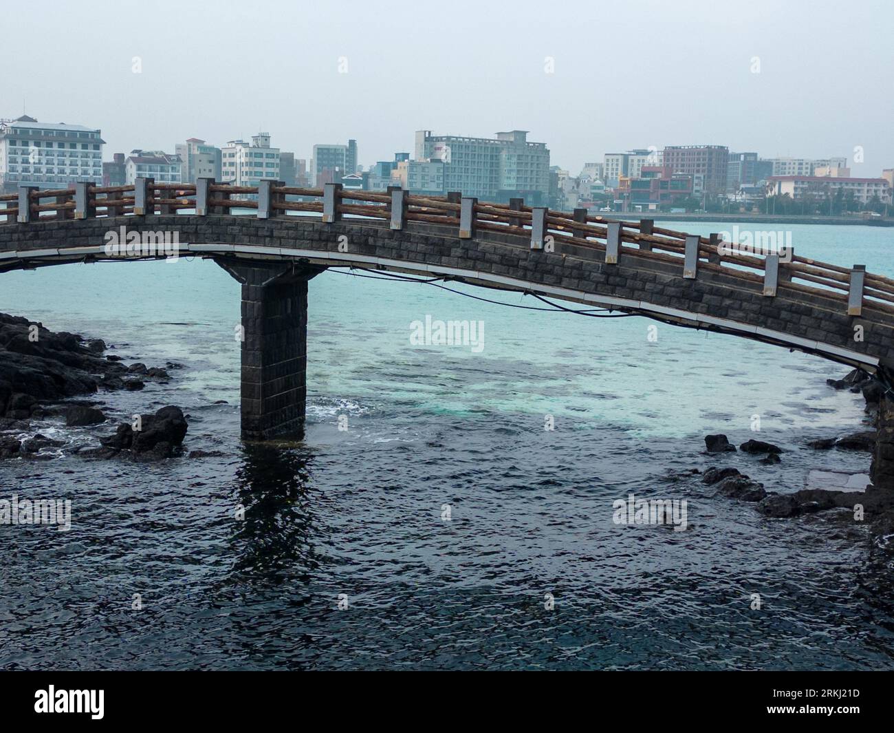 A scenic view of a bridge spanning a body of water near a city skyline: Jeju, South Korea Stock Photo