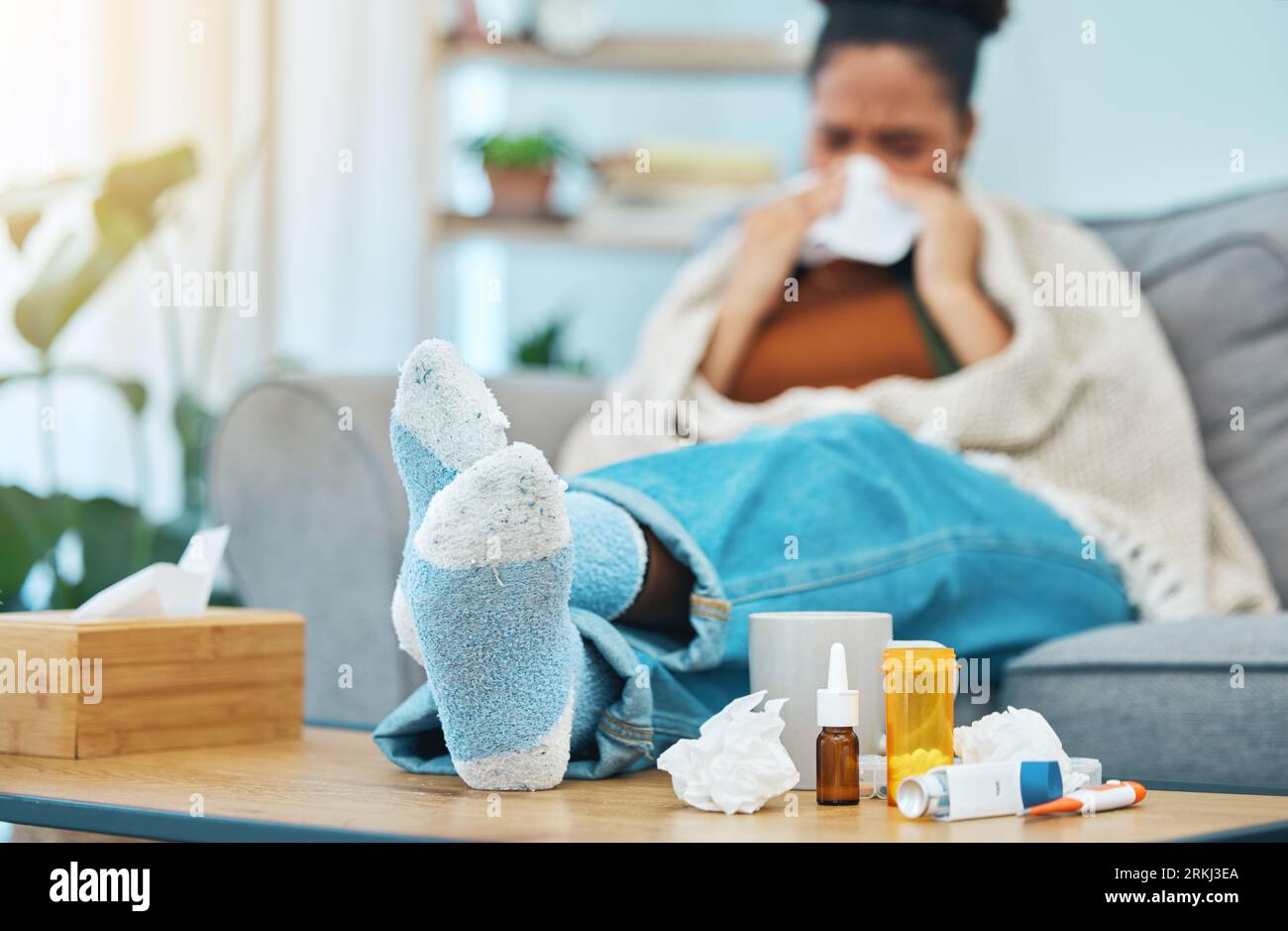 Woman, sick and pills, allergies and medicine with feet on table, healthcare and sinus infection. Virus, bacteria and sneezing, pharmaceutical drugs Stock Photo