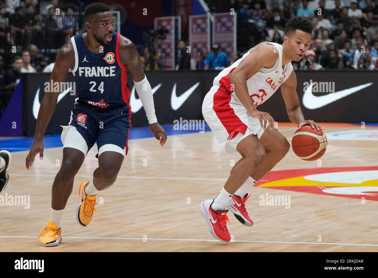 Canada guard Trae Bell-Haynes (25) dribbles past France guard Yakuba  Ouattara (24) during the Basketball World Cup group H match between France  and Canada at the Indonesia Arena stadium in Jakarta, Indonesia,