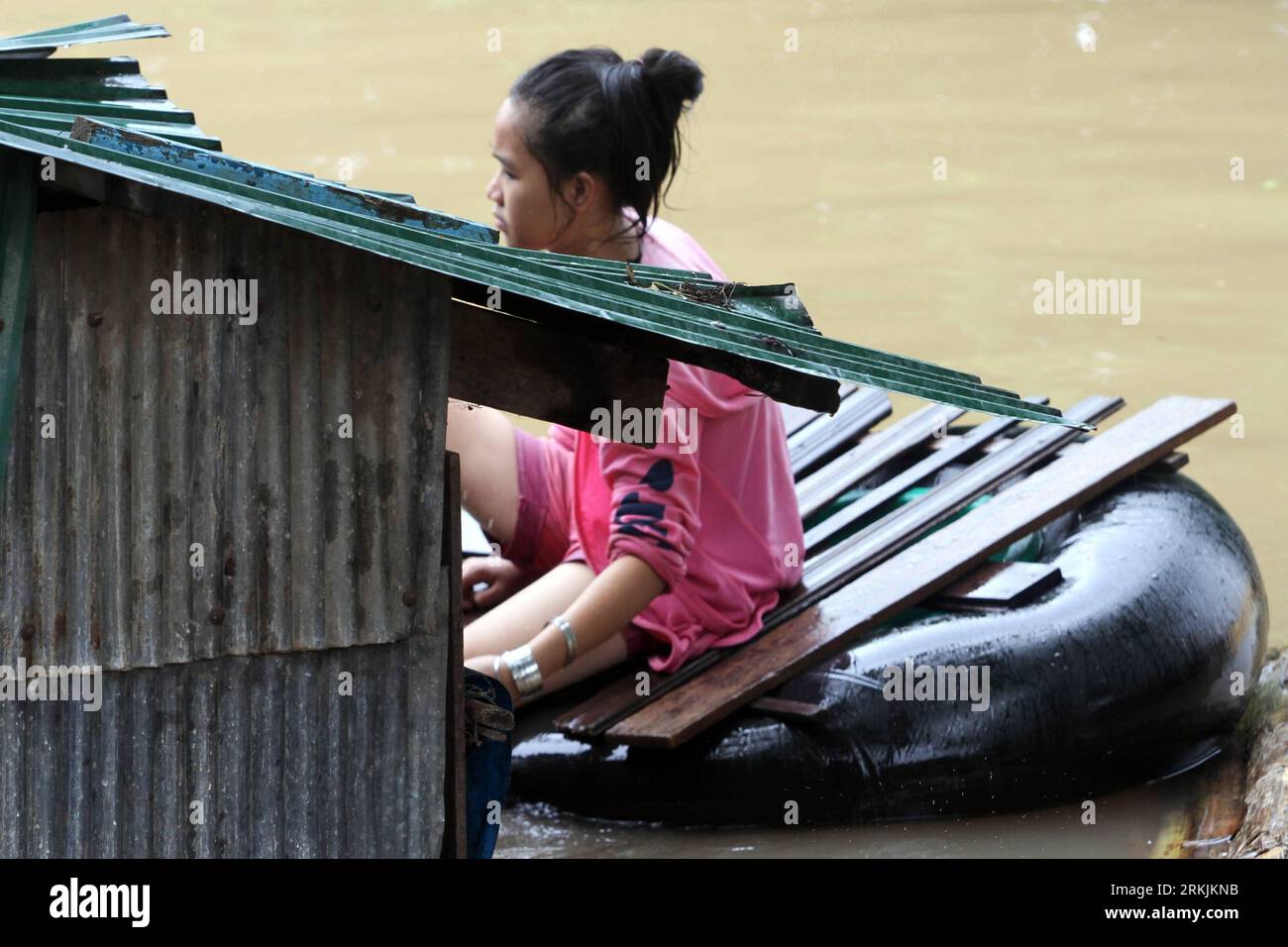 Bildnummer: 56142835  Datum: 03.10.2011  Copyright: imago/Xinhua (111003) -- PHNOM PENH, Oct. 3, 2011 (Xinhua) --A Cambodian girl checks the roof of her house, which is almost inundated by the floodwater along the Mekong River in Phnom Penh s Meanchey district, on Oct. 3, 2011. Cambodia s Deputy Prime Minister said Monday the country has been suffering more serious from global climate change in recent years, referring to the floods that has hit the country since August and killed at least 150 so far. (Xinhua/Philong Sovan) (srb) CAMBODIA-PHNOM PENH-FLOOD PUBLICATIONxNOTxINxCHN Gesellschaft Übe Stock Photo
