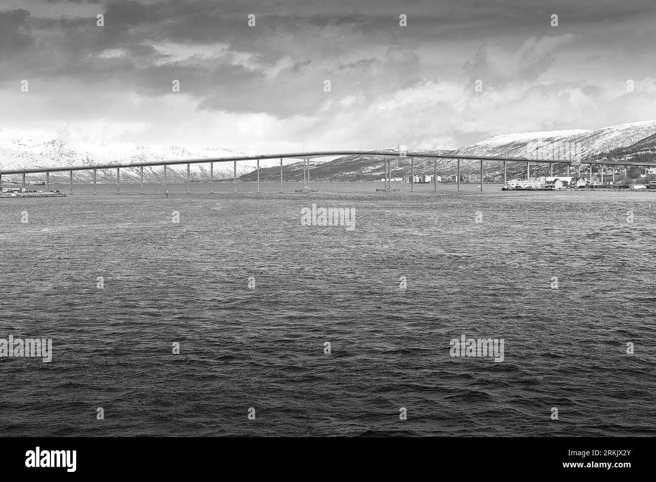 Black And White Photo Of The 1036 Metre Long Tromsø Bridge (Tromsøbrua) Spans The Tromsøysundet Strait To The North Of Tromso City Centre. Norway. Stock Photo