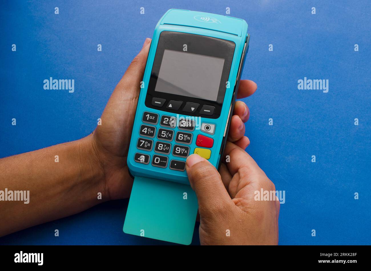 Closeup of hands holding a modern credit card payment device, Contactless technology facilitating fast and secure transactions. Stock Photo