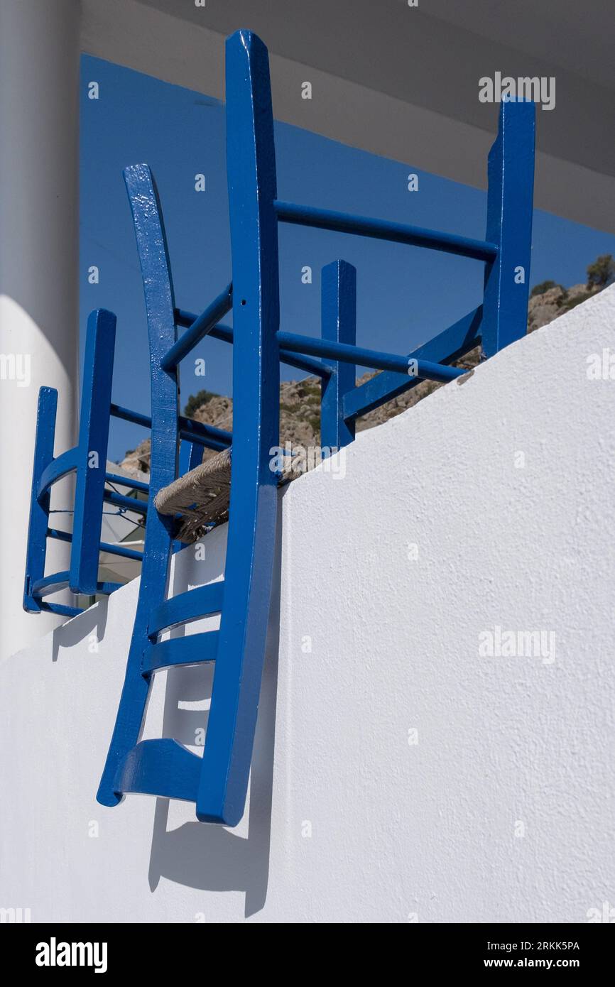 Upside down. Iconic, simple, bluepainted restaurant chairs sit upside