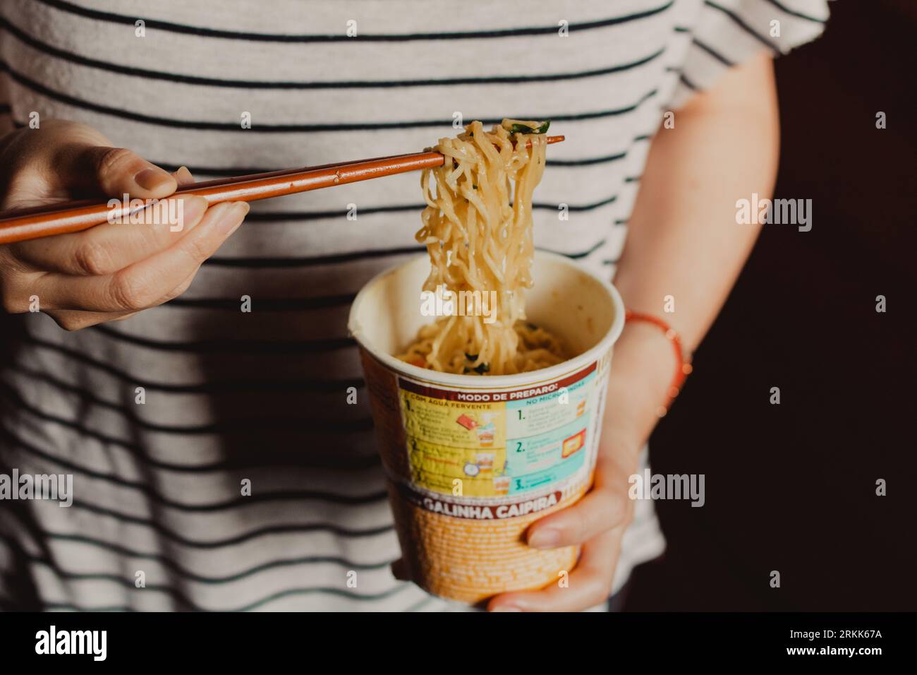 eating cup noodles with chopsticks Stock Photo
