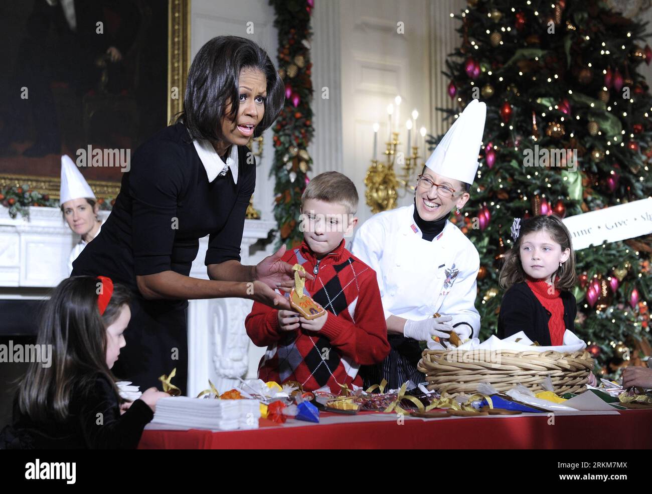 Bildnummer: 56537170  Datum: 30.11.2011  Copyright: imago/Xinhua (111130) -- WASHINGTON, Nov. 30, 2011 (Xinhua) -- U.S. first lady Michelle Obama shows her handmade cookie Christmas ornament while hosting children of active duty military service members in the State Dining Room during the press preview of the Christmas decorations at the White House in Washington D.C., capital of the United States, Nov. 30, 2011. (Xinhua/Zhang Jun) U.S.-WASHINGTON-WHITE HOUSE-CHRISTMAS-DECORATIONS PUBLICATIONxNOTxINxCHN People Gesellschaft Weihnachten Deko Weihnachtsdeko USA Weisses Haus xbs x2x 2011 quer prem Stock Photo