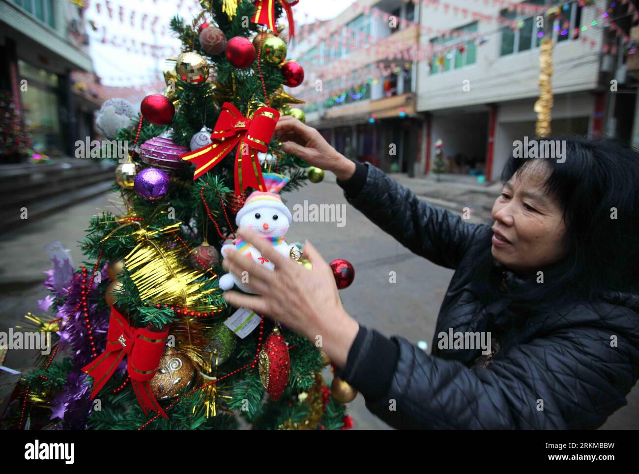 Bildnummer: 56661989  Datum: 06.12.2011  Copyright: imago/Xinhua (111207) -- RUIAN, Dec. 7, 2011 (Xinhua) -- A villager decorates a Christmas tree with ornaments to greet the coming Christmas in Xitan Village of Huling Town in Ruian City, east China s Zhejiang Province, Dec. 6, 2011. Xitan Village, also called the Christmas Village , is famous for its production of Christmas crafts. There are over 240 processing factories and enterprises in the village. The total export sales this year have reached 400 million yuan (about 62 million U.S. dollars) while the domestic sales have added up to 100 m Stock Photo