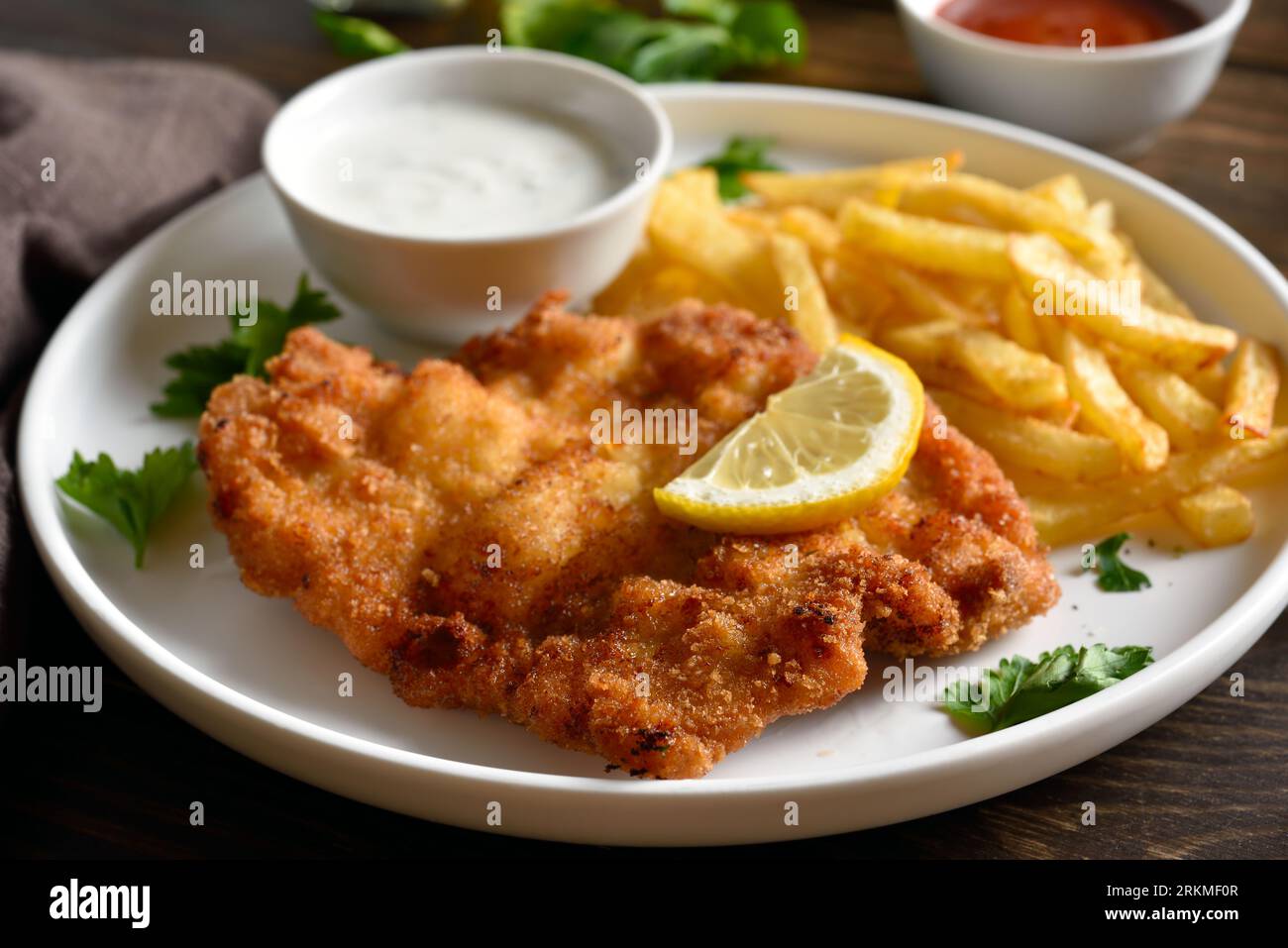 Close up view of breaded wiener schnitzel with potato fries and 