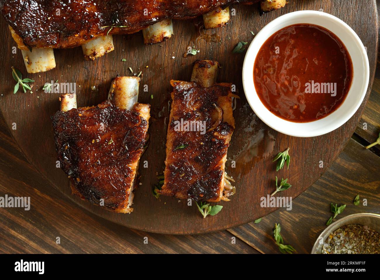 Barbecue pork ribs with tomato sauce on cutting board over wooden background. Top view, flat lay Stock Photo