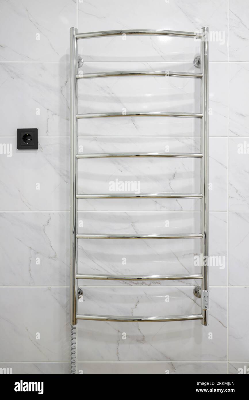 Chrome electric heated towel rail closeup in the bathroom Stock Photo