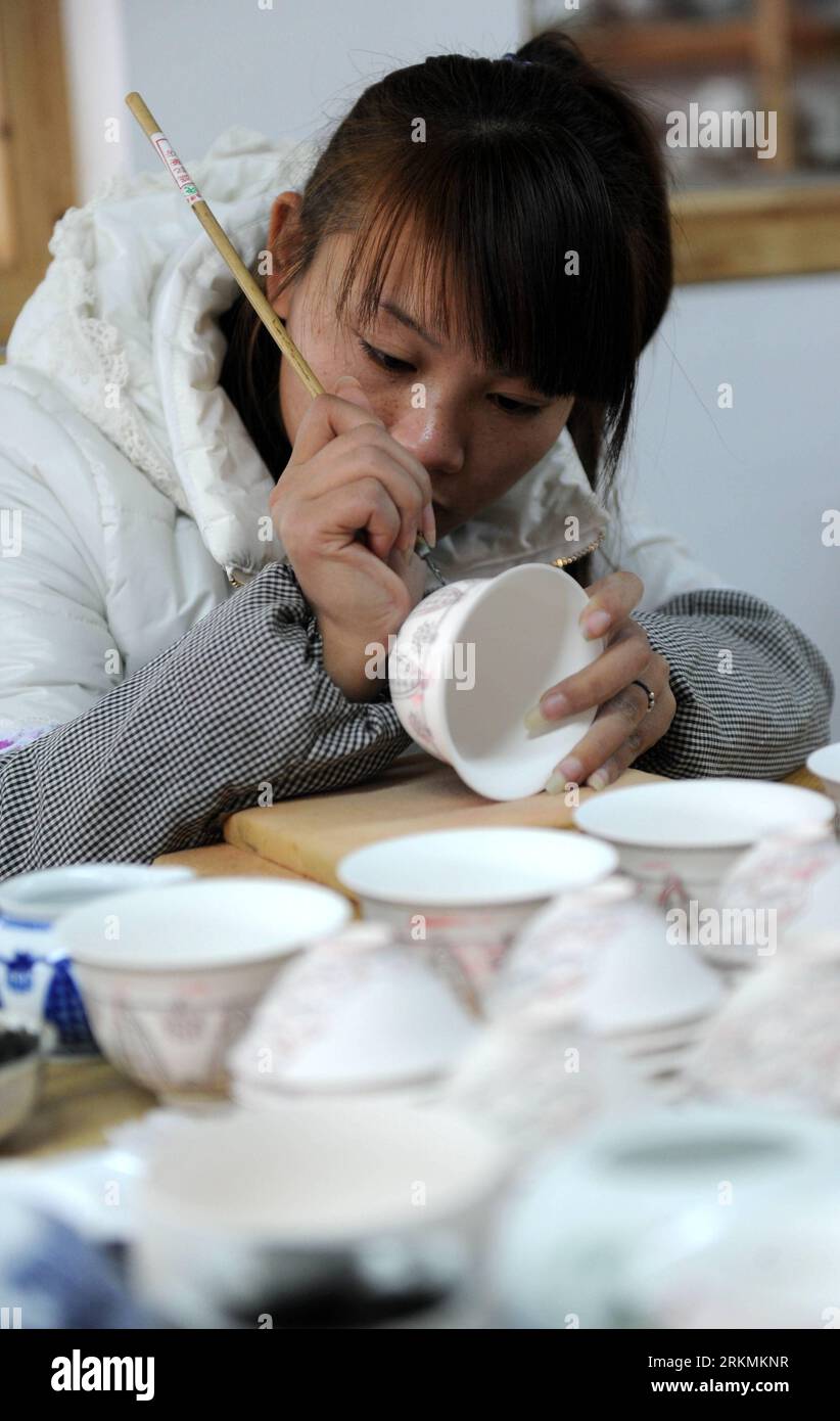 Bildnummer: 56778415  Datum: 21.12.2011  Copyright: imago/Xinhua (111223) -- JINGDEZHEN, Dec. 23, 2011 (Xinhua) -- A technician paints on an adobe at a procelain workshop in Porcelain Capital Jingdezhen City, east China s Jiangxi Province, Dec. 21, 2011. Jingdezhen s percelain has been famous not only in China but in time it became known internationally for being as thin as paper, as white as jade, as bright as a mirror, and as sound as a bell. (Xinhua/Zhou Ke) (xzj) CHINA-JIANGXI-JINGDEZHEN-PORCELAIN (CN) PUBLICATIONxNOTxINxCHN Wirtschaft Porzellan Arbeitswelten Handwerk Gesellschaft xda x0x Stock Photo