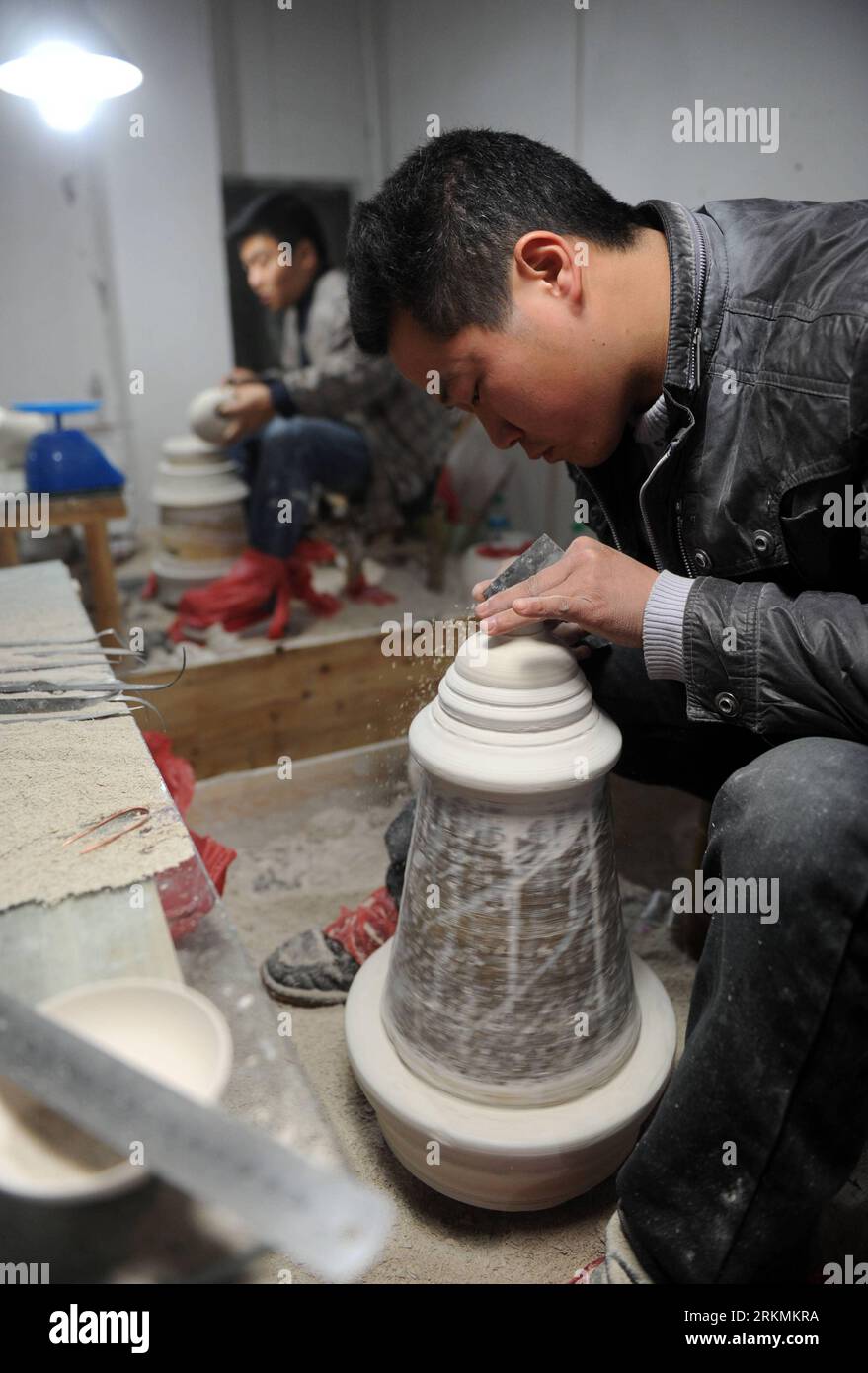 Bildnummer: 56778411  Datum: 21.12.2011  Copyright: imago/Xinhua (111223) -- JINGDEZHEN, Dec. 23, 2011 (Xinhua) -- A technician works on an adobe on a clay-strip machine at a procelain workshop in Porcelain Capital Jingdezhen City, east China s Jiangxi Province, Dec. 21, 2011. Jingdezhen s percelain has been famous not only in China but in time it became known internationally for being as thin as paper, as white as jade, as bright as a mirror, and as sound as a bell. (Xinhua/Zhou Ke) (xzj) CHINA-JIANGXI-JINGDEZHEN-PORCELAIN (CN) PUBLICATIONxNOTxINxCHN Wirtschaft Porzellan Arbeitswelten Handwer Stock Photo