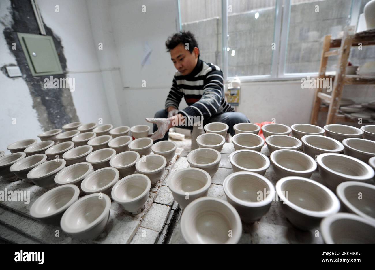 Bildnummer: 56777881  Datum: 21.12.2011  Copyright: imago/Xinhua (111223) -- JINGDEZHEN, Dec. 23, 2011 (Xinhua) -- A worker throws cups from clay at a procelain workshop in Porcelain Capital Jingdezhen City, east China s Jiangxi Province, Dec. 21, 2011. Jingdezhen s percelain has been famous not only in China but in time it became known internationally for being as thin as paper, as white as jade, as bright as a mirror, and as sound as a bell. (Xinhua/Zhou Ke) (lfj) (BRIDING WE) CHINA-JIANGXI-JINGDEZHEN-PORCELAIN (CN) PUBLICATIONxNOTxINxCHN Wirtschaft Porzellan Arbeitswelten Handwerk xda x0x 2 Stock Photo