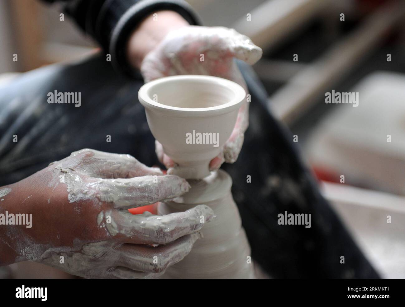 Bildnummer: 56777880  Datum: 21.12.2011  Copyright: imago/Xinhua (111223) -- JINGDEZHEN, Dec. 23, 2011 (Xinhua) -- A worker throws a cup from a ball of clay at a procelain workshop in Porcelain Capital Jingdezhen City, east China s Jiangxi Province, Dec. 21, 2011. Jingdezhen s percelain has been famous not only in China but in time it became known internationally for being as thin as paper, as white as jade, as bright as a mirror, and as sound as a bell. (Xinhua/Zhou Ke) (lfj) CHINA-JIANGXI-JINGDEZHEN-PORCELAIN (CN) PUBLICATIONxNOTxINxCHN Wirtschaft Porzellan Arbeitswelten Handwerk xda x0x 201 Stock Photo
