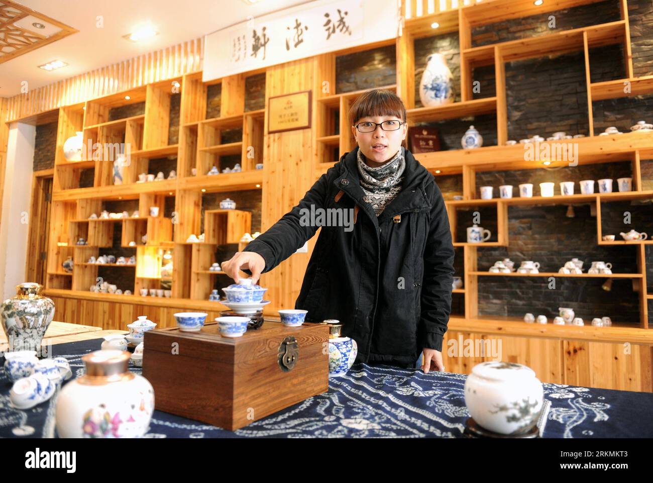 Bildnummer: 56778412  Datum: 21.12.2011  Copyright: imago/Xinhua (111223) -- JINGDEZHEN, Dec. 23, 2011 (Xinhua) -- A staff member introduces the products at a procelain workshop in Porcelain Capital Jingdezhen City, east China s Jiangxi Province, Dec. 21, 2011. Jingdezhen s percelain has been famous not only in China but in time it became known internationally for being as thin as paper, as white as jade, as bright as a mirror, and as sound as a bell. (Xinhua/Zhou Ke) (xzj) CHINA-JIANGXI-JINGDEZHEN-PORCELAIN (CN) PUBLICATIONxNOTxINxCHN Wirtschaft Porzellan Arbeitswelten Handwerk Gesellschaft x Stock Photo