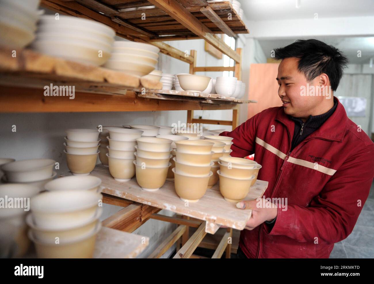 Bildnummer: 56777877  Datum: 21.12.2011  Copyright: imago/Xinhua (111223) -- JINGDEZHEN, Dec. 23, 2011 (Xinhua) -- A worker carries porcelain adobes for firing at a procelain workshop in Porcelain Capital Jingdezhen City, east China s Jiangxi Province, Dec. 21, 2011. Jingdezhen s percelain has been famous not only in China but in time it became known internationally for being as thin as paper, as white as jade, as bright as a mirror, and as sound as a bell. (Xinhua/Zhou Ke) (lfj) CHINA-JIANGXI-JINGDEZHEN-PORCELAIN (CN) PUBLICATIONxNOTxINxCHN Wirtschaft Porzellan Arbeitswelten Handwerk xda x0x Stock Photo