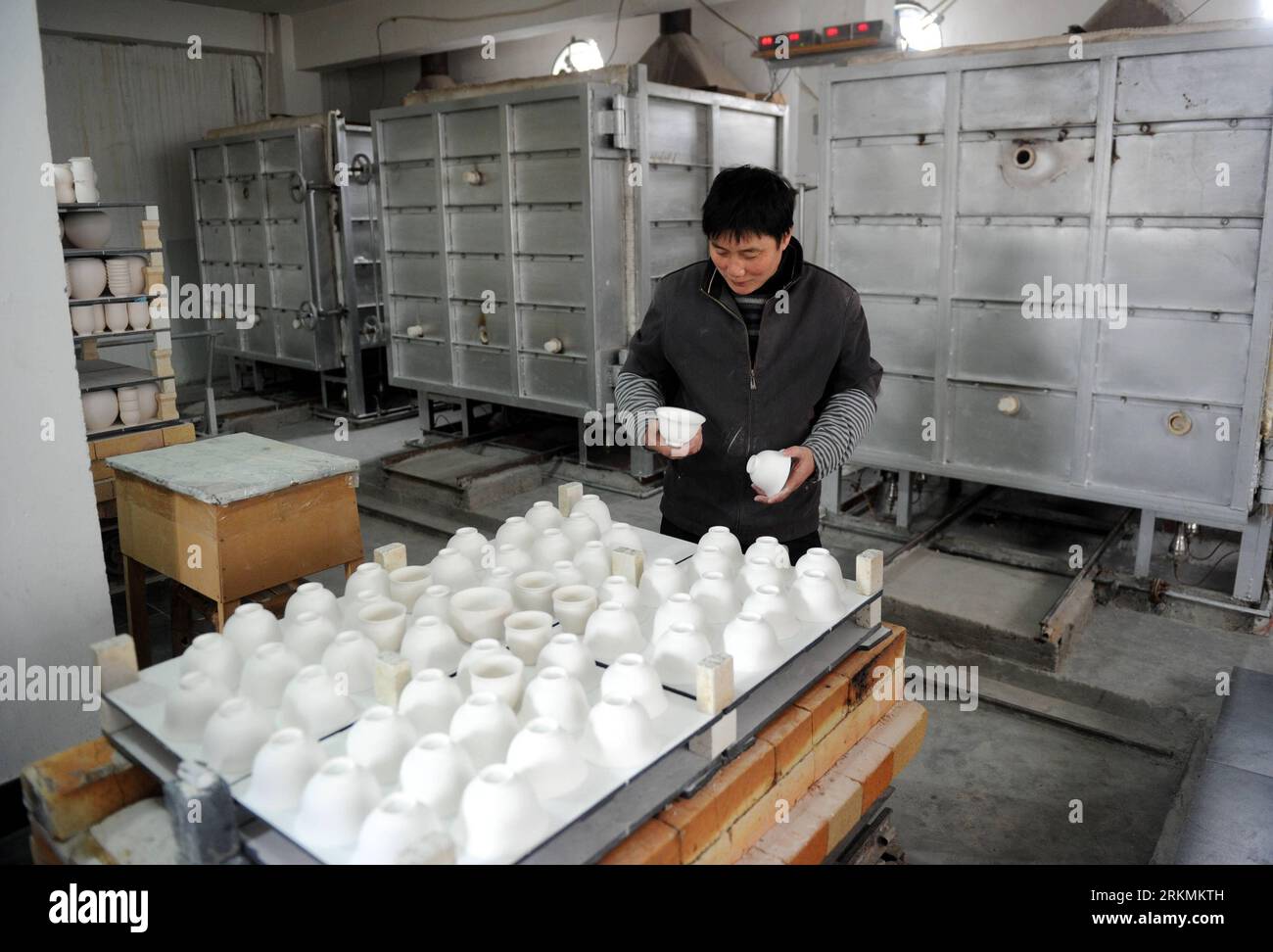 Bildnummer: 56778413  Datum: 21.12.2011  Copyright: imago/Xinhua (111223) -- JINGDEZHEN, Dec. 23, 2011 (Xinhua) -- A technician places adobes at a procelain workshop in Porcelain Capital Jingdezhen City, east China s Jiangxi Province, Dec. 21, 2011. Jingdezhen s percelain has been famous not only in China but in time it became known internationally for being as thin as paper, as white as jade, as bright as a mirror, and as sound as a bell. (Xinhua/Zhou Ke) (xzj) (BRIDING WE) CHINA-JIANGXI-JINGDEZHEN-PORCELAIN (CN) PUBLICATIONxNOTxINxCHN Wirtschaft Porzellan Arbeitswelten Handwerk Gesellschaft Stock Photo