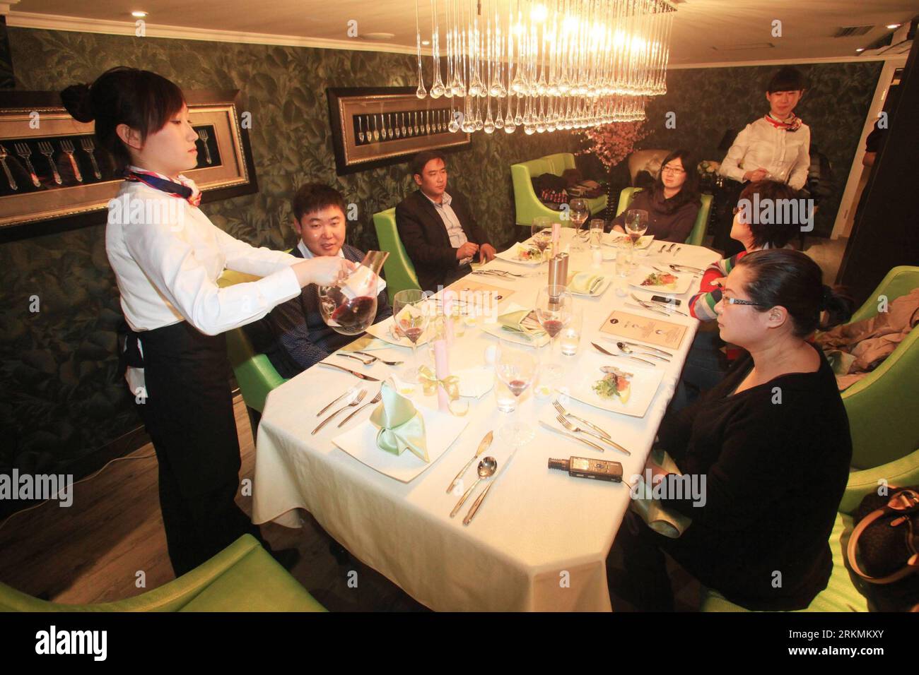 Bildnummer: 56783497  Datum: 22.12.2011  Copyright: imago/Xinhua (111223) -- TIANJIN, Dec. 23, 2011 (Xinhua) -- Waitresses pour wine for customers in a Russian restaurant which was newly opened in the Kiev, a former Soviet Union aircraft carrier now transformed into a hotel, in the Binhai Aircraft Carrier Theme Park in Tianjin Municipality, north China, Dec. 22, 2011. (Xinhua/Wang Huan) (llp) CHINA-TIANJIN-AIRCRAFT CARRIER KIEV-RUSSIAN RESTAURANT-OPENING (CN) PUBLICATIONxNOTxINxCHN Wirtschaft Gastronomie Restaurant Schiff Militär Militärschiff Flugzeugträger kurios x0x xst premiumd 2011 quer Stock Photo
