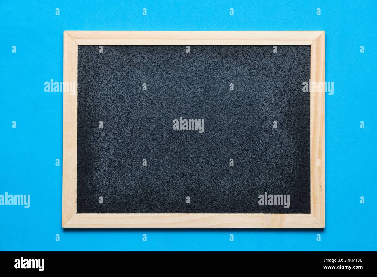 Black blackboard for notes in wooden frame blue background Stock Photo