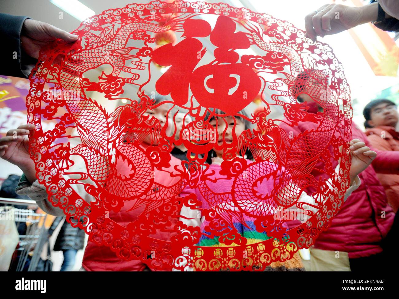 Bildnummer: 56968459  Datum: 25.01.2012  Copyright: imago/Xinhua (120126) -- SHENYANG, Jan. 26, 2012 (Xinhua) -- Two young girls look at the dragon-shaped paper-cutting works in Shenyang, capital of northeast China s Liaoning Province, Jan. 25, 2012. Handicrafts inspired by dragon became very popular in China as the Spring Festival, which fell on Jan. 23, marked the start of the Year of Dragon according to the Chinese zodiac. (Xinhua/Zhang Wenkui) (ry) CHINA-DRAGON-IMAGE-POPULARITY (CN) PUBLICATIONxNOTxINxCHN Gesellschaft Tradition Figur Jahr des Drachen xbs x0x 2012 quer      56968459 Date 25 Stock Photo