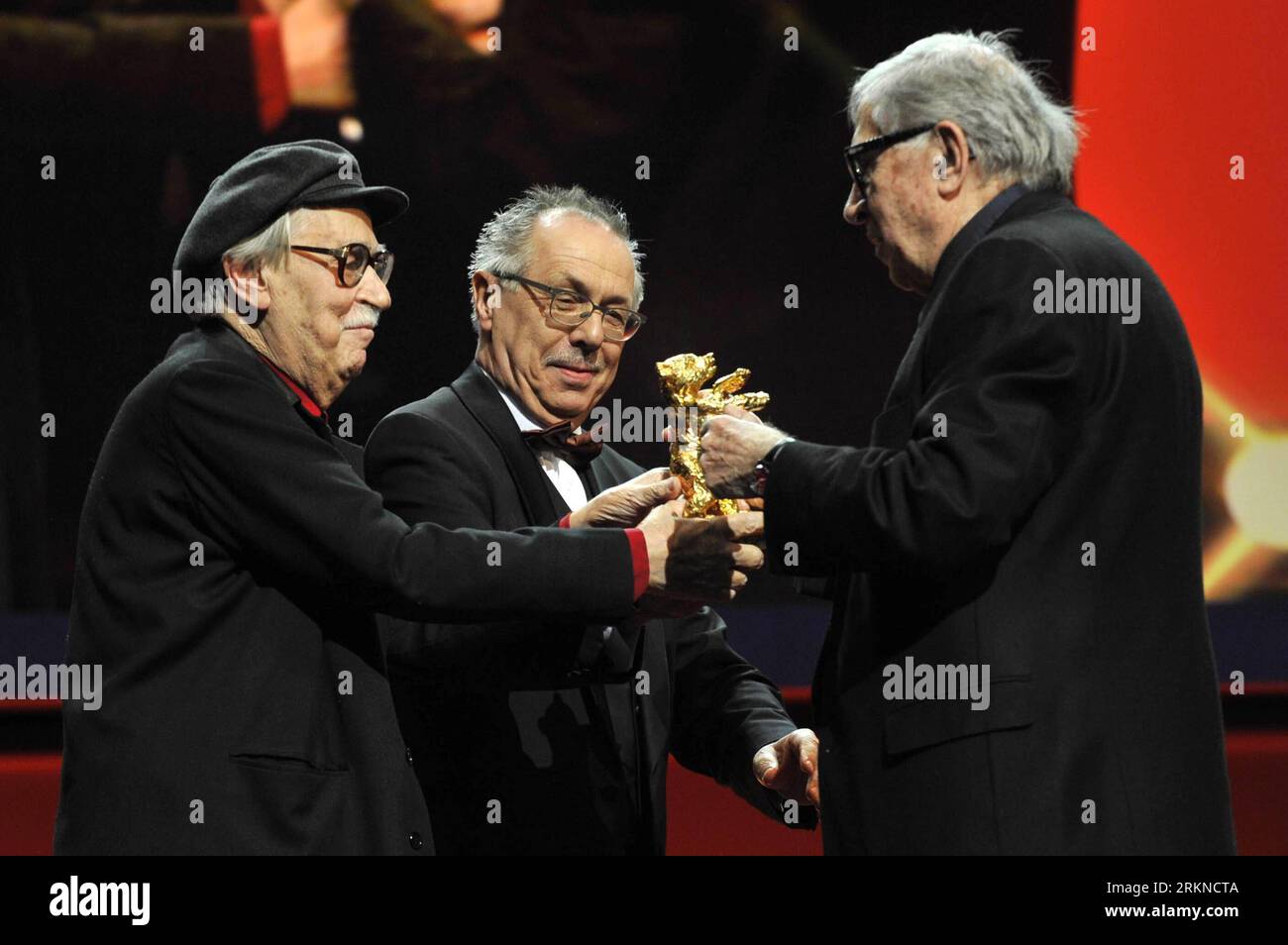 (120218) -- BERLIN, Feb. 18, 2012 (Xinhua) -- Italian directors Paolo Taviani (L) and Vittorio Taviani (C) for the movie Caesare Deve Morire ( Caesar Must Die ) receive the Golden Bear award for the best film from Berlinale s director Dieter Kosslick (R) during the awards ceremony at the 62nd Berlinale film festival in Berlin, capital of Germany, on Feb. 18, 2012. (Xinhua/Ma Ning) (yy) GERMANY-BERLINALE FILM FESTIVAL- PUBLICATIONxNOTxINxCHN Stock Photo