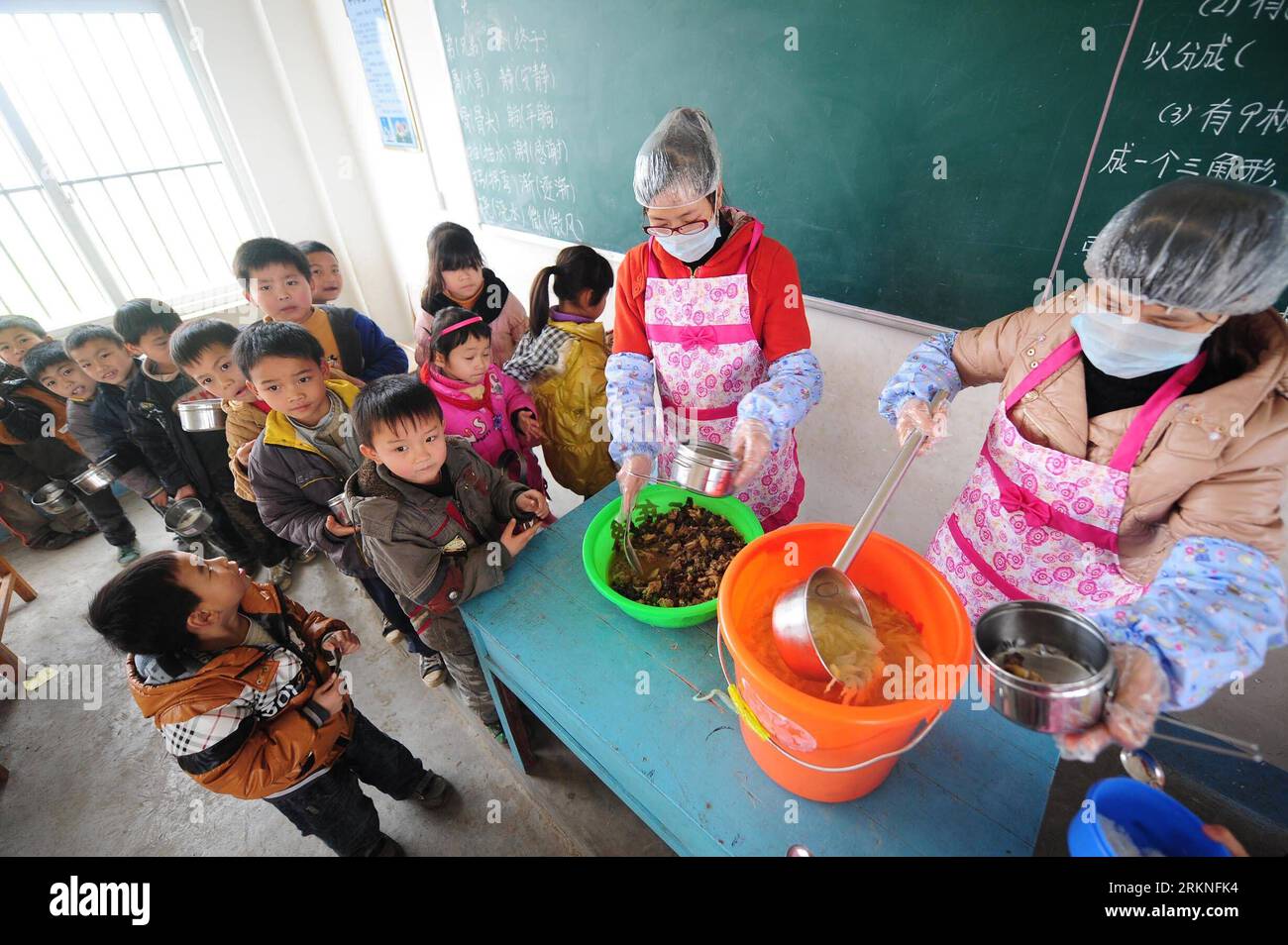 Bildnummer: 57114288  Datum: 27.02.2012  Copyright: imago/Xinhua (120227) -- MASHAN, Feb. 27, 2012 (Xinhua) -- Pupils queue up to get lunch at the classroom of Neixue Primary School in Baishan Township of Mashan County, south China s Guangxi Zhuang Autonomous Region, Feb. 23, 2012. Local government of the poverty-stricken county has input 9.71 million yuan (1.54 million U.S. dollars) since May last year to build or improve dining halls in 117 primary and secondary schools. Companies and charity organizations also joined in the program to offer free lunch to rural students in Mashan. Altogether Stock Photo