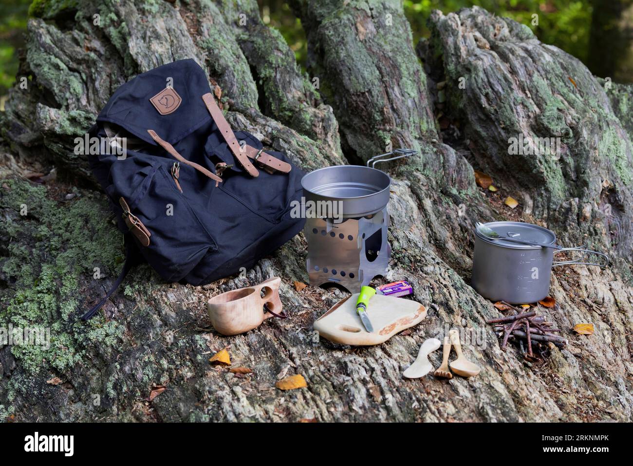 backpack with outdoor equipment on a tree root Stock Photo