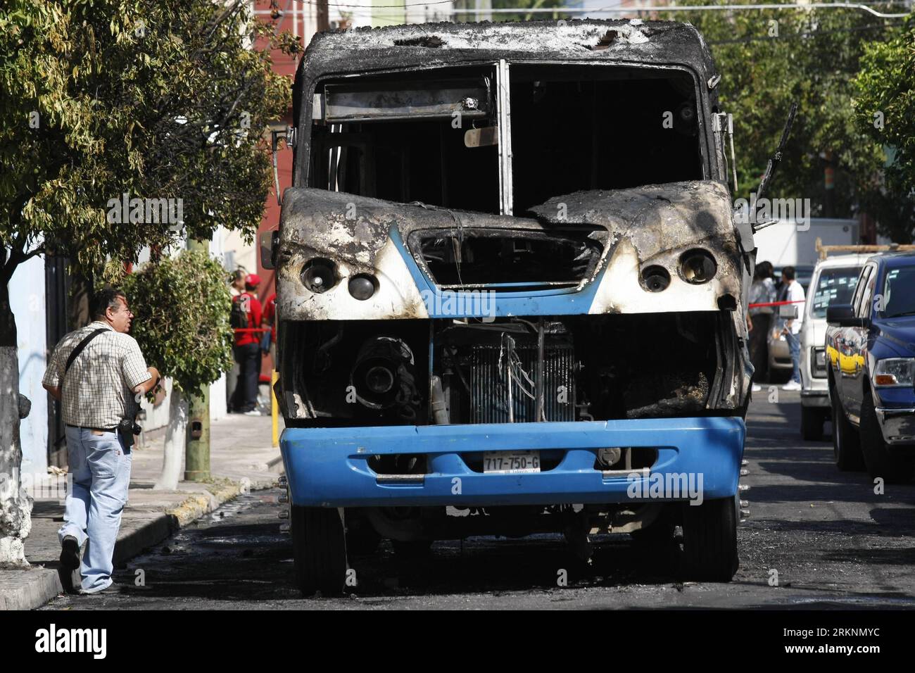 Bildnummer: 57330451  Datum: 09.03.2012  Copyright: imago/Xinhua (120310) -- GUADALAJARA, March 10, 2012 (Xinhua) -- A journalist stands in front of a burning bus used as a roadblock during a series of clashes between authorities and the organized crime, in the city of Guadalajara, Mexico, March 9, 2012. Around 16 places of the metropolitan area of Guadalajara were affected with burned vehicles causing roadblocks. According to the local press, an operation was conducted by elements of the Mexican Army against the cartel of Jalisco Nueva Generacion (Jalisco s New Generation), one of whose leade Stock Photo