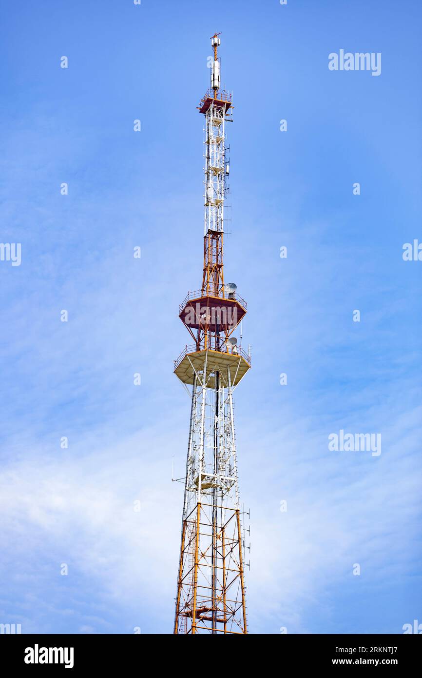 A telecommunications tower typical of Eastern Europe. Metal structure against the blue sky. Stock Photo