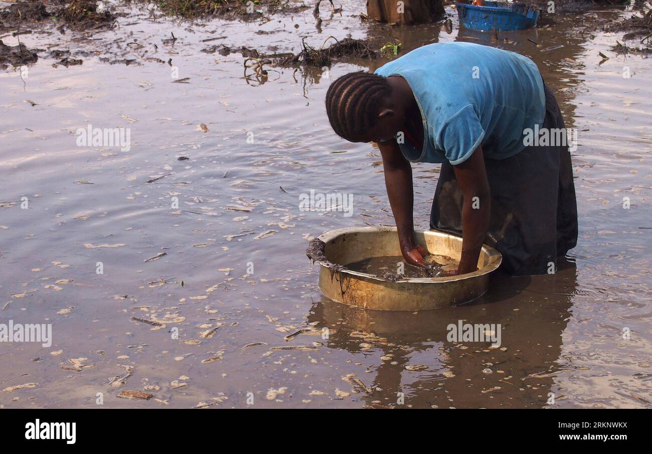 Bildnummer: 57577415  Datum: 20.03.2012  Copyright: imago/Xinhua (120321) -- KOLE(Uganda), March 21, 2012 (Xinhua) -- A woman collects mud in a basin in search of mud fish in the northern Ugandan district of Kole on March 20, 2012. As the region recovers from ruins of war, many in rural areas still live without clean water. Statistics show that as of June 2011, access to safe water in the rural areas has stagnated at 65 percent, while in the urban areas, it has reduced from 67 percent to 66 percent. (Xinhua/Yuan Qing) (zw) UGANDA-WORLD WATER DAY-DRINKING WATER SAFETY PUBLICATIONxNOTxINxCHN Ges Stock Photo
