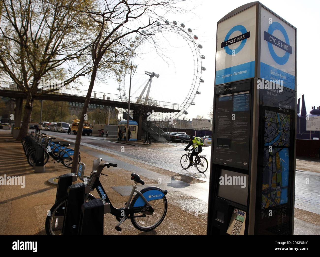 Bildnummer: 57930489  Datum: 25.04.2012  Copyright: imago/Xinhua (120425) -- LONDON, April 25, 2012 (Xinhua) -- A cyclist is seen past the Jubilee Gardens of Cycle Hire docking station in London, Britain, on April 13, 2012. London launched its Cycle Hire scheme on July 30, 2010, with 315 bicycle docking stations and 5,000 bicycles available. Londoners and visitors joining the scheme can rent and dock bicycles at any station with the first 30 minutes of any journey for free. (Xinhua/Wang Lili) (lr) ZOOM-IN ENVIRONMENT UK-LONDON-CYCLE HIRE PUBLICATIONxNOTxINxCHN Gesellschaft Fahrradverleih Leihr Stock Photo