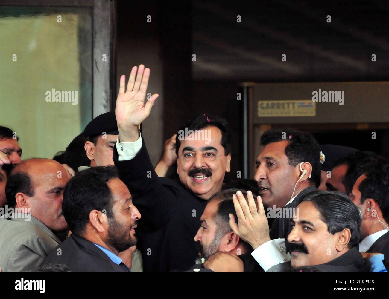 Bildnummer: 57933512  Datum: 26.04.2012  Copyright: imago/Xinhua (120426) -- ISLAMABAD, April 26, 2012 (Xinhua) -- Pakistani Prime Minister Yousuf Raza Gilani (C) is escorted by security members as he waves upon his arrival at the Supreme Court building in Islamabad, capital of Pakistan, on April 26, 2012. Pakistan s Supreme Court on Thursday found Prime Minister Yusuf Raza Gilani guilty of contempt of court for failing to act on its directives to reopen graft cases against President Asif Ali Zardari. (Xinhua/Ahmad Kamal) (lyx) PAKISTAN-PRIME MINISTER-GUILTY OF CONTEMPT OF COURT PUBLICATIONxNO Stock Photo