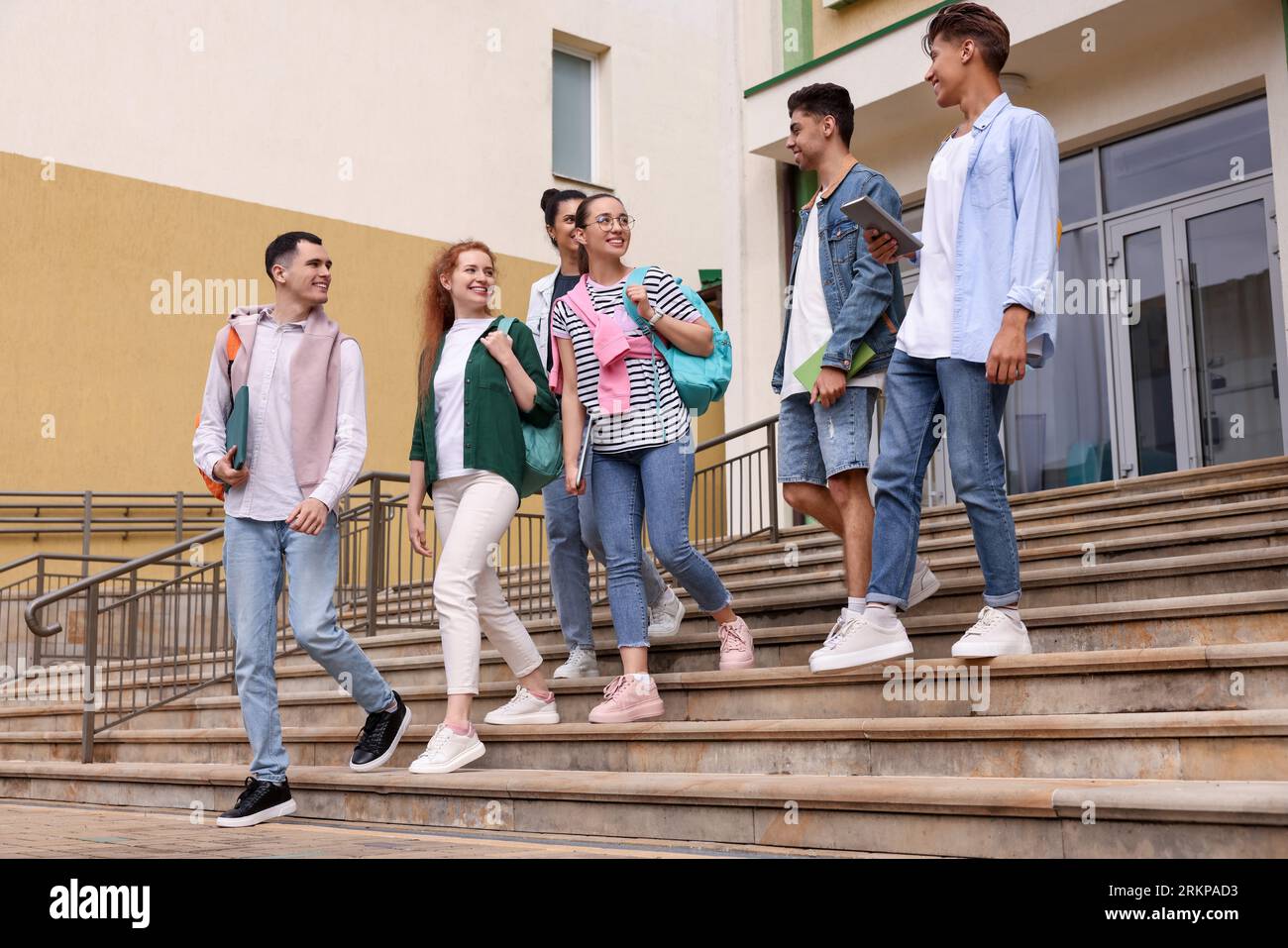 Group of happy young students walking down stairs outdoors Stock Photo ...