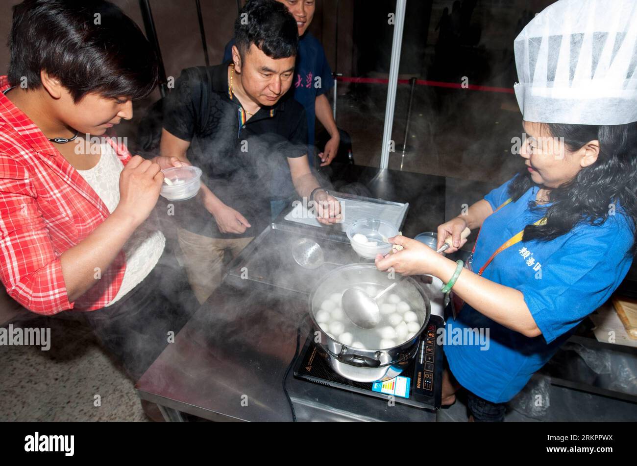 Bildnummer: 58045071  Datum: 29.05.2012  Copyright: imago/Xinhua (120529) -- BEIJING, May 29, 2012 (Xinhua) -- Visitors try Sichuan-style sweet dumplings at the first China Beijing International Fair for Trade in Services (CIFTIS) in Beijing, capital of China, May 29, 2012. Opening Monday in Beijing, the CIFTIS attracted exhibitors of various Chinese cuisines, including the best-known Sichuan, Shandong, Guangdong and Huaiyang cuisines. (Xinhua/Zhang Yu) (lmm) CHINA-BEIJING-CIFTIS-CHINESE CUISINES (CN) PUBLICATIONxNOTxINxCHN Wirtschaft Gesellschaft Messe Gastromie xda x2x 2012 quer   o0 Teigtas Stock Photo