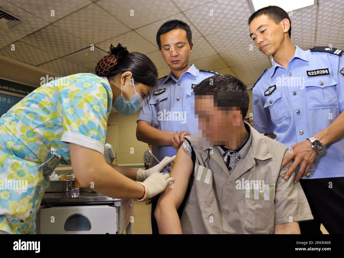 Bildnummer: 58115360  Datum: 18.06.2012  Copyright: imago/Xinhua (120618) -- CHONGQING, June 18, 2012 (Xinhua) -- The prisoner father surnamed Gao (R, front), is injected with medical agent before donating his stem cells to his son Jun Jie at Xinqiao Hospital in Chongqing, southwest China, June 12, 2012. A family is facing an anxious wait to see whether a bone marrow transplant, made possible by the incarcerated father s rare trans-provincial prison transfer, has saved their son s life. PUBLICATIONxNOTxINxCHN Gesellschaft Fotostory Leukämie Medizin Knochenmarkspende Stammzellen Stammzellenther Stock Photo