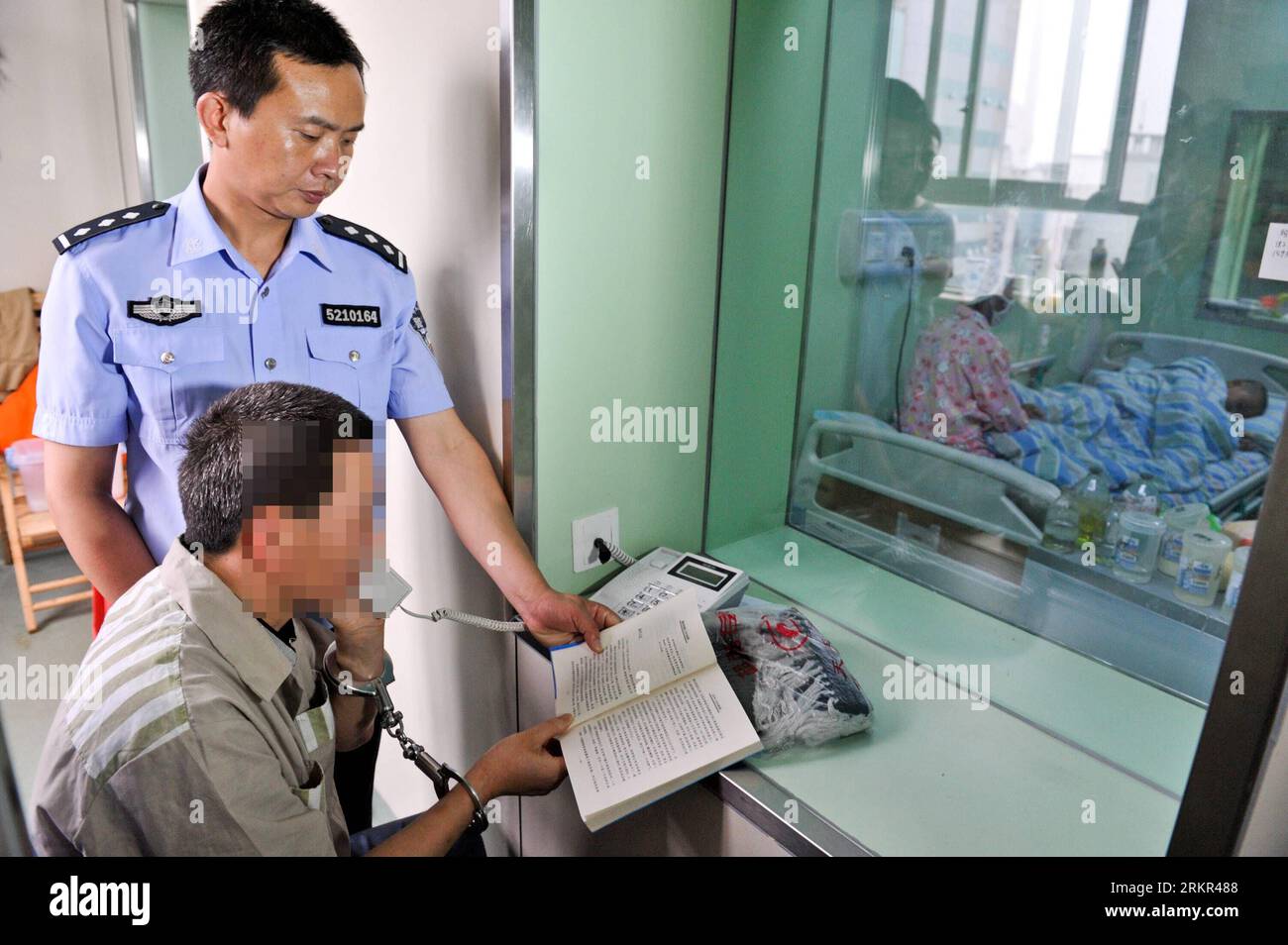 Bildnummer: 58115355  Datum: 18.06.2012  Copyright: imago/Xinhua (120618) -- CHONGQING, June 18, 2012 (Xinhua) -- The prisoner father surnamed Gao (C) reads stories for his son through a phone outside the patient ward at Xinqiao Hospital in Chongqing, southwest China, June 12, 2012. A family is facing an anxious wait to see whether a bone marrow transplant, made possible by the incarcerated father s rare trans-provincial prison transfer, has saved their son s life. PUBLICATIONxNOTxINxCHN Gesellschaft Fotostory Leukämie Medizin Knochenmarkspende Stammzellen Stammzellentherapie Spende xjh x2x 20 Stock Photo