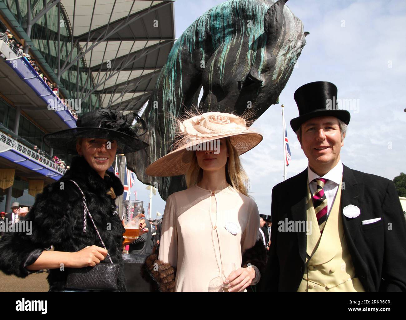 Bildnummer: 58133968  Datum: 21.06.2012  Copyright: imago/Xinhua (120622) -- London, June 21, 2012 (Xinhua) -- Women wearing hats pose with a man for photo on the Royal Ascot, in Ascot, Berkshire, UK, June 21, 2012. Dated from 1711, the annual Royal Ascot week is one of Europe s most famous horse racing event. The Thursday in every Royal Ascot week is the traditional Ladies Day, on which spectating ladies specially wear beautiful hats for the Gold Cup race. (Xinhua/Zhang Yuenan) (zy) UK-ROYAL ASCOT-LADIES DAY PUBLICATIONxNOTxINxCHN Entertainment Galopp Royal Ascot Mode xjh x0x premiumd 2012 qu Stock Photo