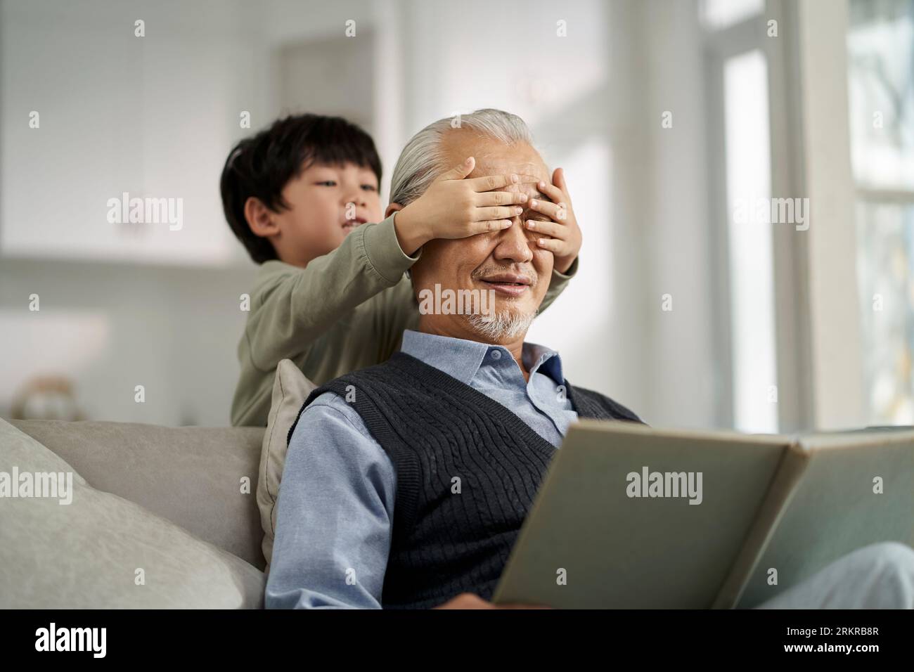 senior asian grandfather having a good time with grandson at home Stock Photo