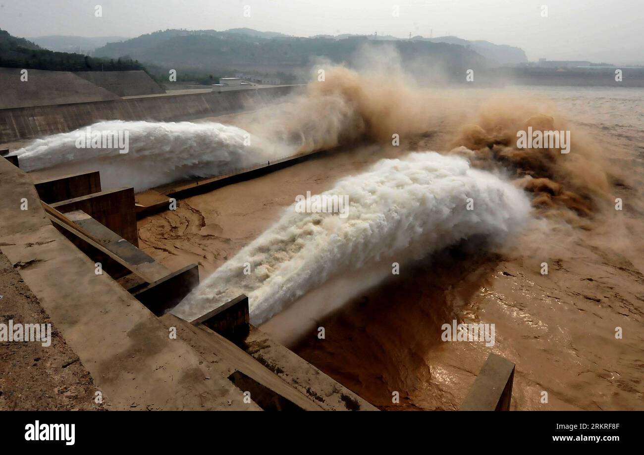 Silt-laden water rushing over a weir on the River Stour Blandford Dorset  England UK Stock Photo - Alamy