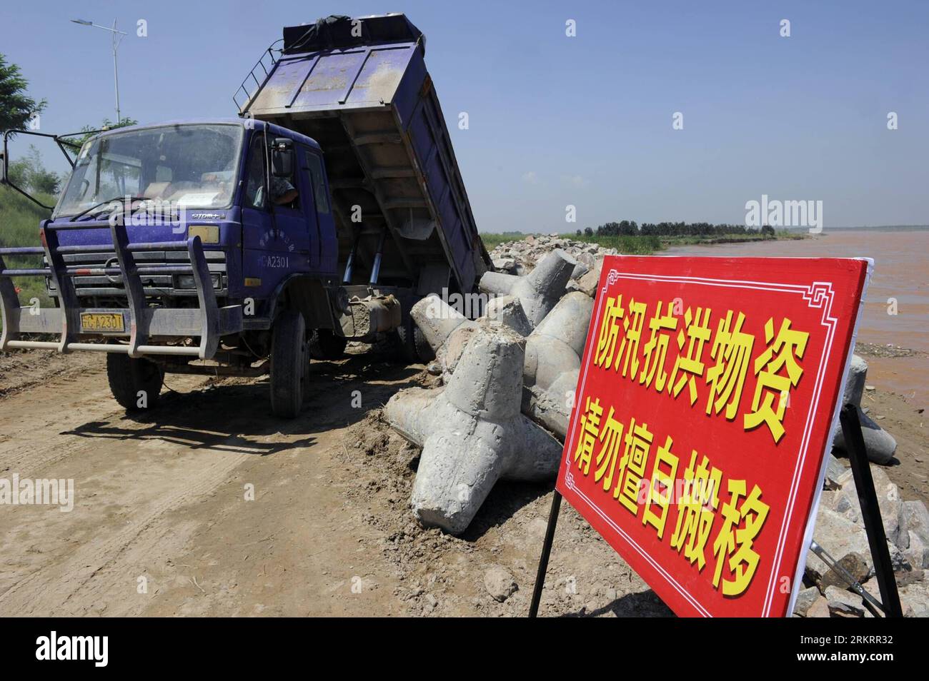 Bildnummer: 58298540  Datum: 01.08.2012  Copyright: imago/Xinhua (120801) -- YINCHUAN, Aug. 1, 2012 (Xinhua) -- A vehicle unloads stones to reinforce embankment in the Luojiahu section of the Yellow River in northwest China s Ningxia Hui Autonomous Region, Aug. 1, 2012. The highest flood peak of the Yellow River since 1989 hit the Ningxia section on Tuesday. Local flood control headquarters has initiated a level-three emergency response to cope with possible flooding. (Xinhua/Wang Peng)(mcg) CHINA-NINGXIA-FLOOD PEAK (CN) PUBLICATIONxNOTxINxCHN Gesellschaft Hochwasser Gelber Fluss Huanghe Vorbe Stock Photo