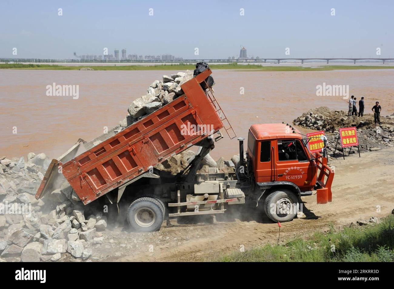 Bildnummer: 58298537  Datum: 01.08.2012  Copyright: imago/Xinhua (120801) -- YINCHUAN, Aug. 1, 2012 (Xinhua) -- A vehicle unloads stones to reinforce embankment in the Luojiahu section of the Yellow River in northwest China s Ningxia Hui Autonomous Region, Aug. 1, 2012. The highest flood peak of the Yellow River since 1989 hit the Ningxia section on Tuesday. Local flood control headquarters has initiated a level-three emergency response to cope with possible flooding. (Xinhua/Wang Peng)(mcg) CHINA-NINGXIA-FLOOD PEAK (CN) PUBLICATIONxNOTxINxCHN Gesellschaft Hochwasser Gelber Fluss Huanghe Vorbe Stock Photo