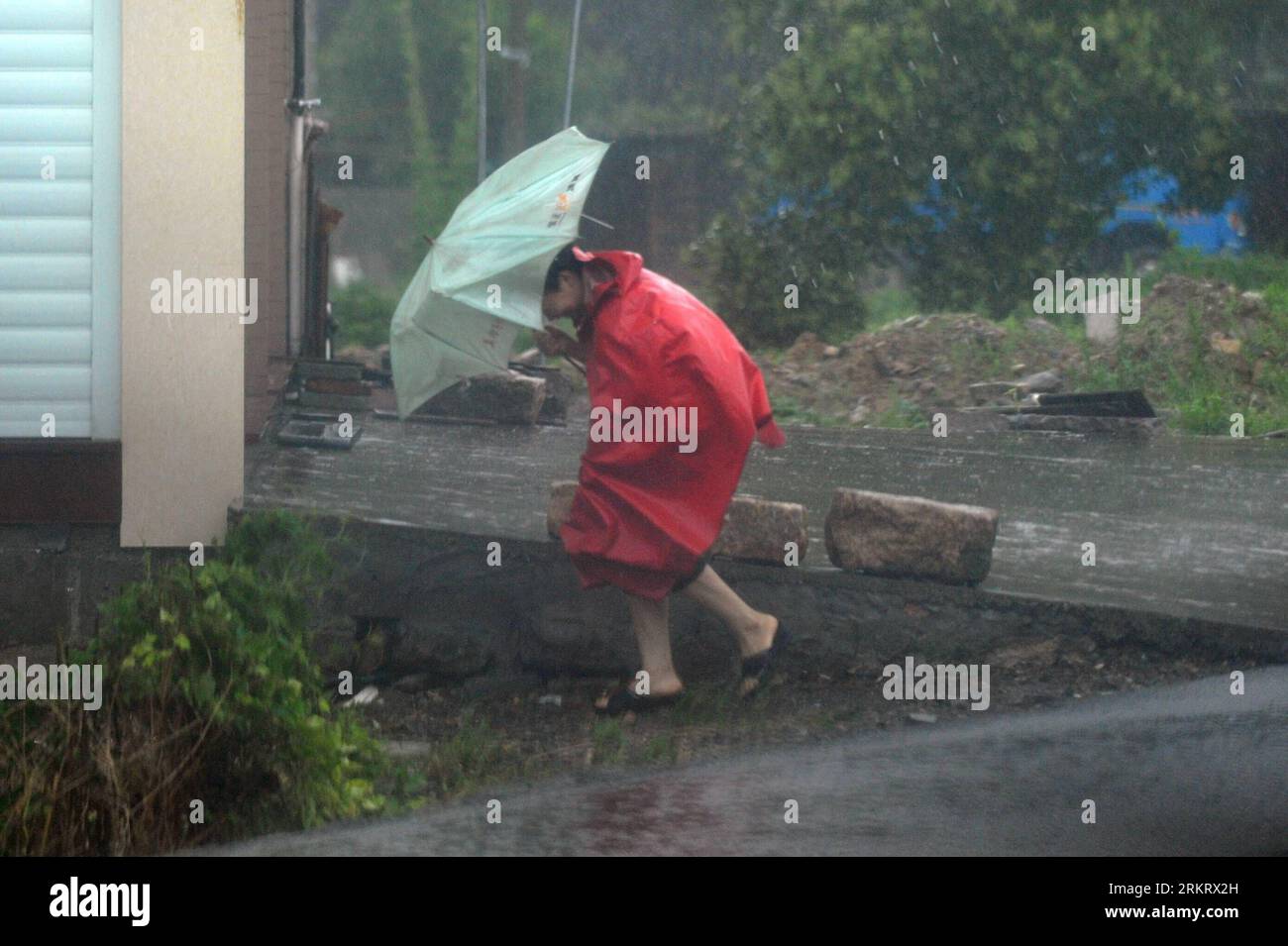 Bildnummer: 58321112  Datum: 07.08.2012  Copyright: imago/Xinhua (120807) -- XIANGSHAN, Aug. 7, 2012 (Xinhua) -- A citizen holding an umbrella walks against the gale in Shipu Town, Xiangshan County, east China s Zhejiang Province, Aug. 7, 2012. Typhoon Haikui strengthened into a severe typhoon Tuesday as it approached the coast of east China s Zhejiang Province, the provincial observatory said Tuesday. According to the latest forecast, Haikui is expected to make landfall on late Tuesday night or Wednesday morning near the Sanmenwan Gulf of Zhejiang. (Xinhua/Huang Zongzhi) (zc) CHINA-ZHEJIANG-T Stock Photo