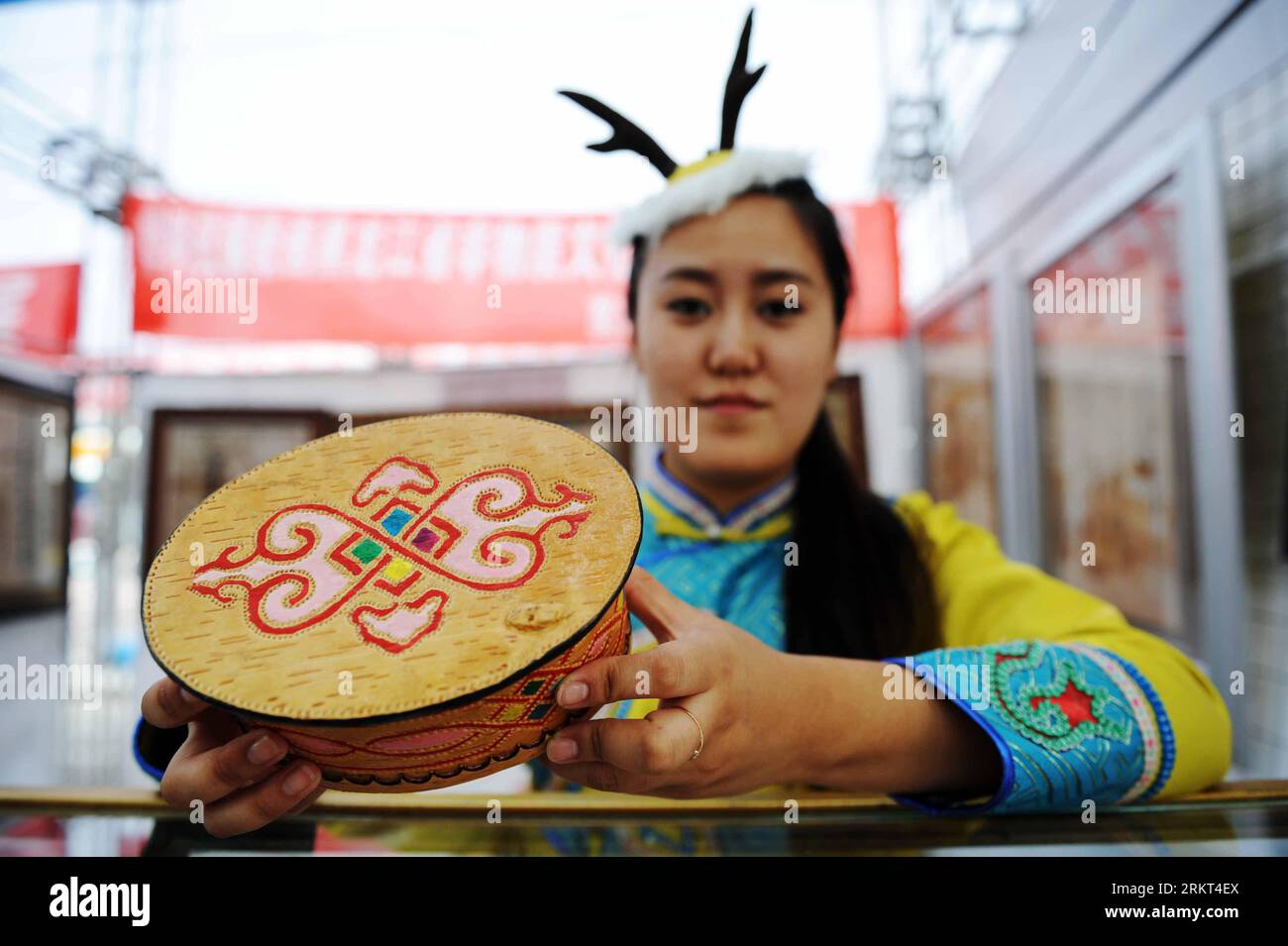 Bildnummer: 58367224  Datum: 19.08.2012  Copyright: imago/Xinhua (120821) -- HEIHE, Aug. 21, 2012 (Xinhua) -- A girln of China s Oroqen ethnic group shows a handicraft made of birch bark during the third China-Russia Cultural Festival in Heihe, northeast China s Heilongjiang Province, Aug. 19, 2012. The week-long cultural event, launched on Sunday, is jointly hosted by Heihe and the neighbouring Russian city of Blagoveshchensk. The festival presents a variety of art performances and artpieces to showcase the cultures of both countries. (Xinhua/Wang Jianwei) (lmm) CHINA-HEILONGJIANG-HEIHE-RUSSI Stock Photo