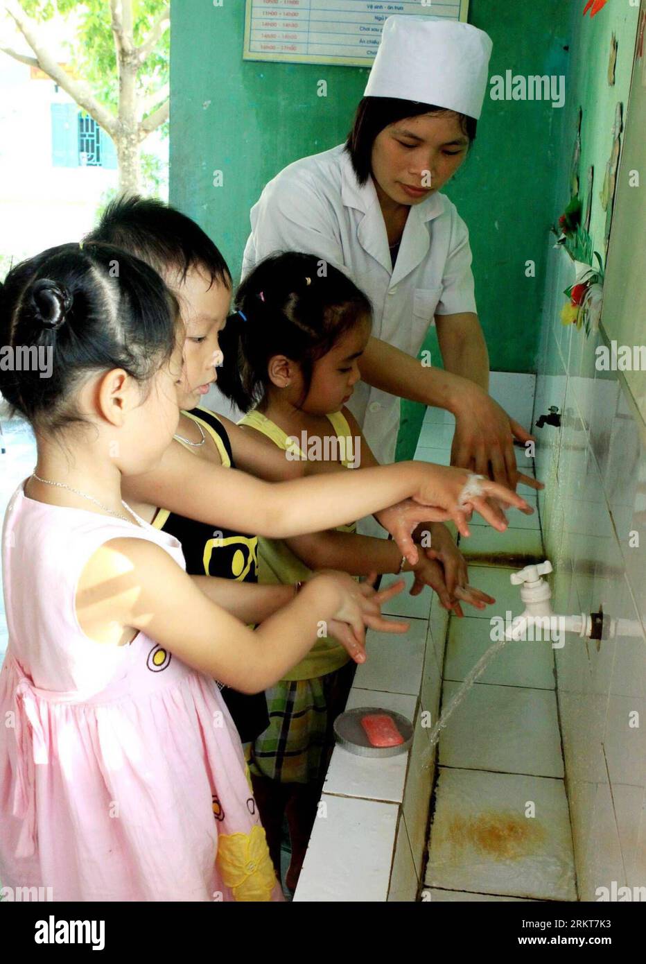 Bildnummer: 58398900  Datum: 28.08.2012  Copyright: imago/Xinhua (120828) -- HANOI, Aug. 28, 2012 (Xinhua) -- A member of Vietnam s health staff instructs children to properly wash hands to prevent seasonal diseases in Vietnam s northern province of Bac Giang, Aug. 28, 2012. Vietnamese government carried out precautionary measures in kindergartens and schools recently to prevent dengue fever, hand-foot-mouth disease, flu and diarrhea. (Xinhua/VNA) VIETNAM-BAC GIANG-DISEASE-PREVENTION PUBLICATIONxNOTxINxCHN Gesellschaft Arbeitswelten Krankenschwester Kinder Bildung Schule Schüler Hygiene x0x xs Stock Photo
