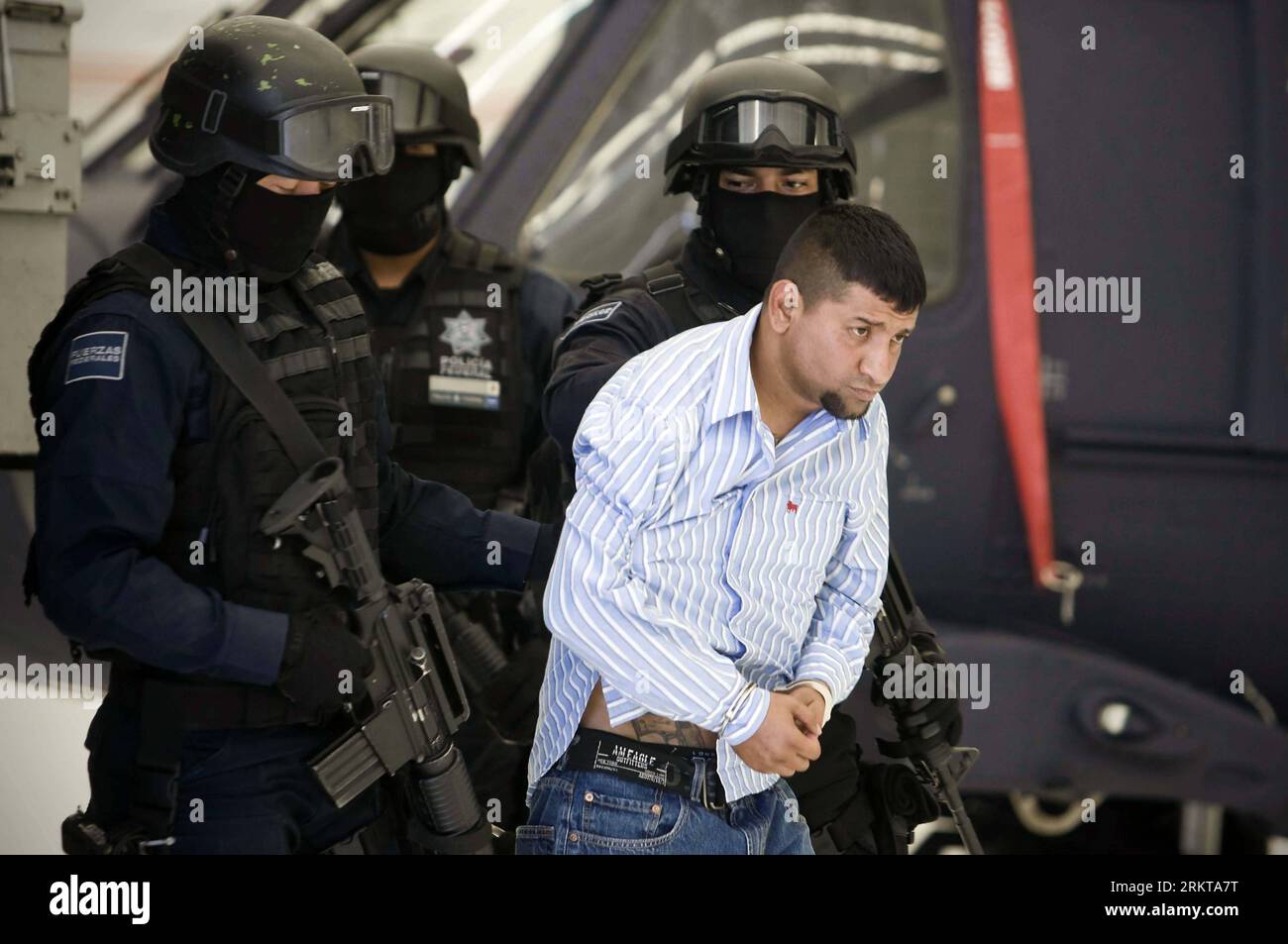 Bildnummer: 58419040  Datum: 02.09.2012  Copyright: imago/Xinhua (120902) -- MEXICO CITY, Sept. 2012 (Xinhua) -- David Rosales Guzman (R), also known as Commander Devil , is escorted by Mexican Federal Police agents during a press conference in Mexico City, capital of Mexico, on Sept. 2, 2012. As the leader of criminal organization Cartel del Golfo in Monterrey, Guzman was arrested for suspected multiple murders, extortions, kidnappings and armed attacks in public areas, according to the Secretary of State for Public Security. (Xinhua/Rodrigo Oropeza) MEXICO-DRUGS-SUSPECT PUBLICATIONxNOTxINxCH Stock Photo