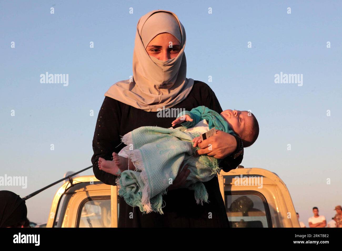 Bildnummer: 58437239  Datum: 05.09.2012  Copyright: imago/Xinhua (120906) -- AMMAN, Sept. 6, 2012 (Xinhua) -- A Syrian refugee holds a child at the al-Thunebah village on Jordan-Syria border Sept. 5, 2012. Jordan, a neighbor of the unrest-hit Syria, is confronted by a more and more daunting challenge brought about by the huge influx of Syrians, who are becoming a growing burden on the country s scarce resources, according to analysts and officials. (Xinhua/Mohammad Abu Ghosh) (nxl) JORDAN-SYRIA-BORDER-REFUGEE PUBLICATIONxNOTxINxCHN Politik Flüchtlinge Bürgerkrieg xjh x0x premiumd 2012 quer Stock Photo