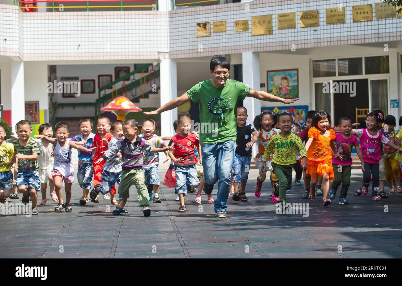 Bildnummer: 58441264  Datum: 07.09.2012  Copyright: imago/Xinhua (120907) -- TONGXIANG, Sept. 7, 2012 (Xinhua) -- Wang Yu plays game with children during an outdoor lesson at a kindergarten in Wutong Street of Tongxiang, east China s Zhejiang Province, Sept. 7, 2012. The 29-year-old Wang Yu is the first male kindergarten teacher in Tongxiang. As a graduate of preprimary education, Wang held the attitude of try when he started his work. Most of his classmates gave up after one or two years. On the contrast, Wang fell in love with his career gradually. He organized sports meet, outdoor activitie Stock Photo