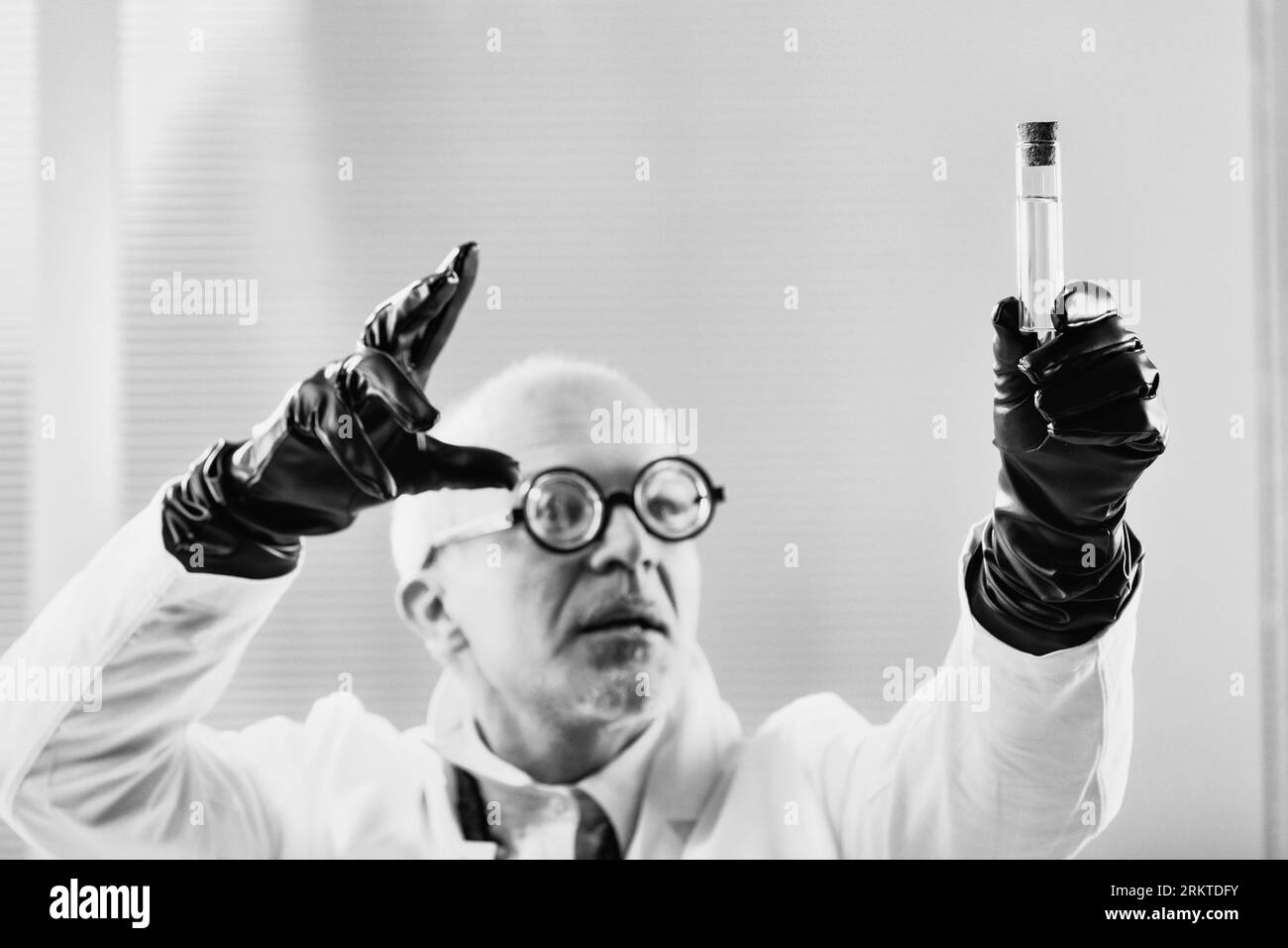 Mastermind in a lab coat devises forbidden substances in a black and white early 20th-century setting, hinting at concealed alliances with or deceptio Stock Photo